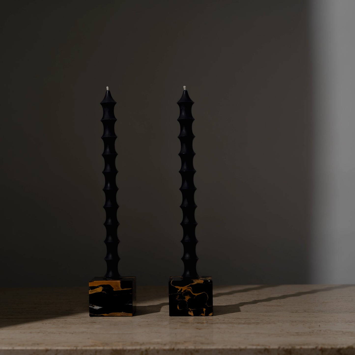 Hand-poured bamboo pagoda-shaped beeswax taper candles in midnight black color, set of two in vintage black marble candleholders with gold veining