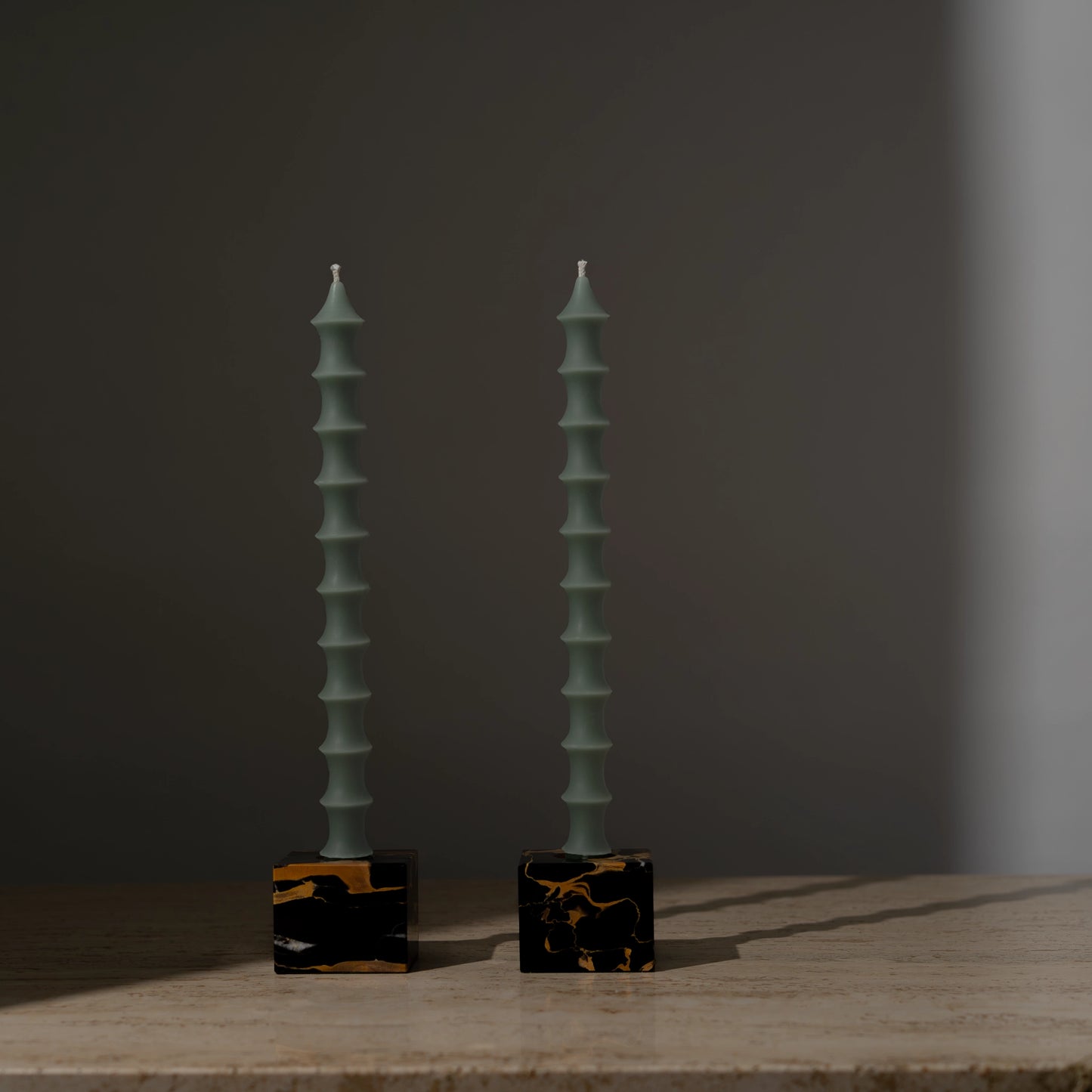 Hand-poured bamboo pagoda-shaped beeswax taper candles in jasper green color, set of two in vintage black marble candleholders with gold veining