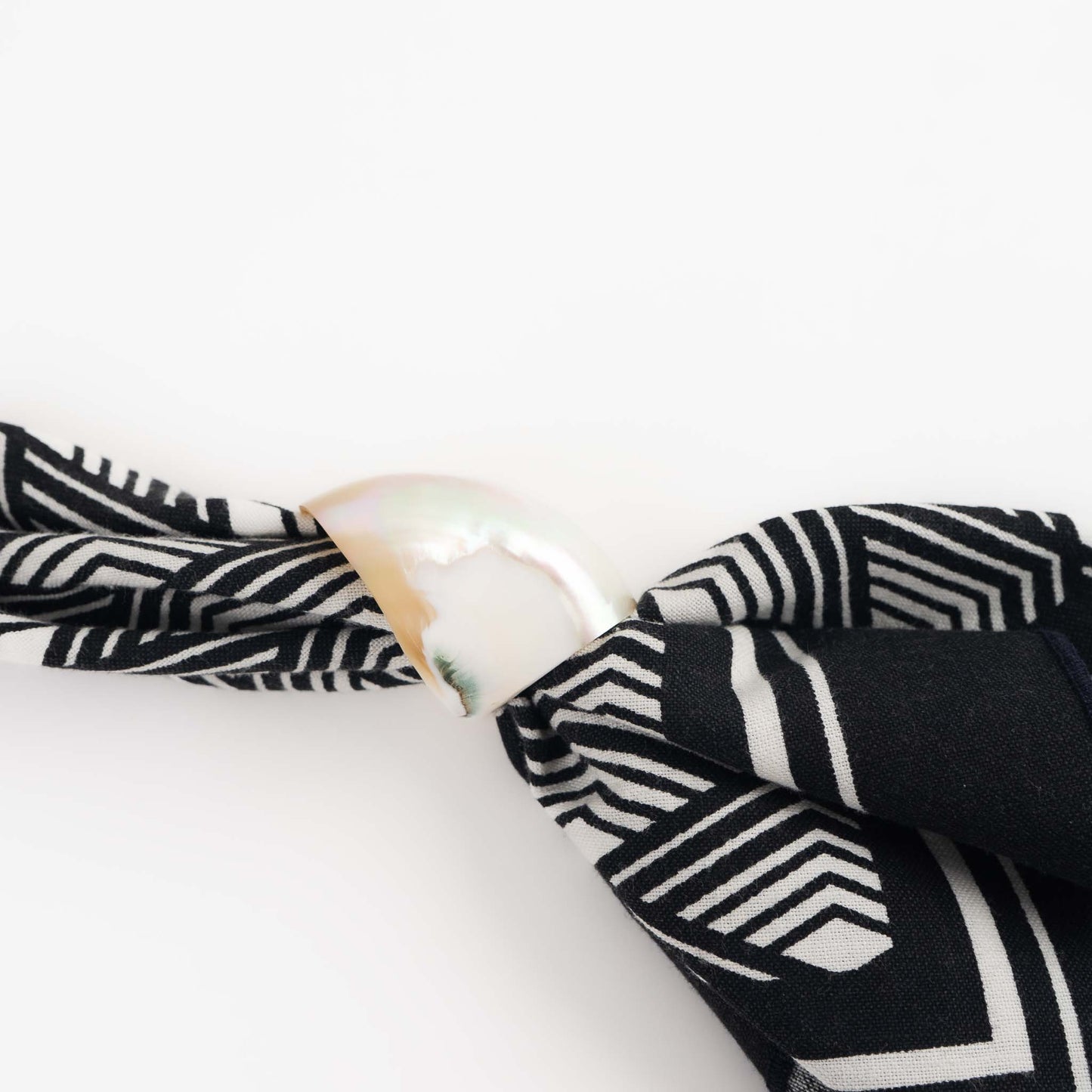 close up of a vintage natural seashell napkin ring on a vintage cloth napkin