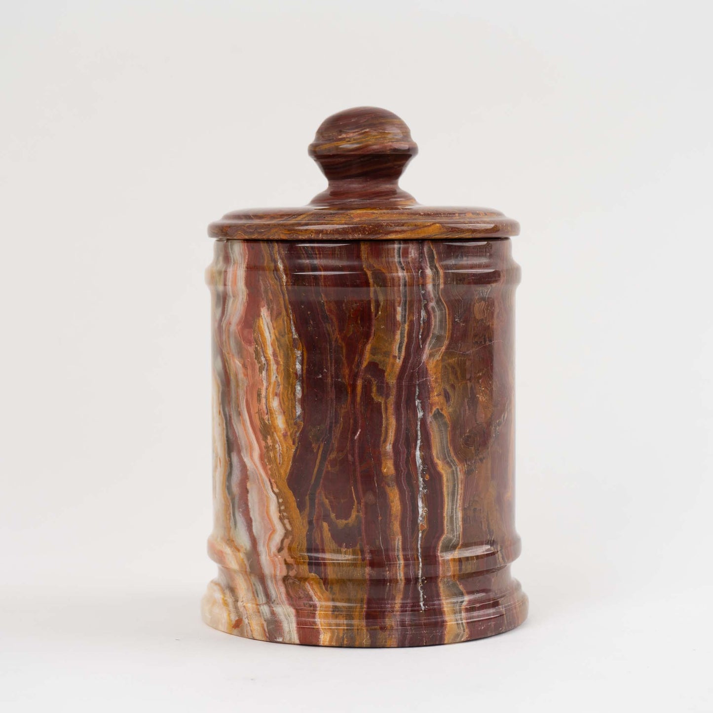 Vintage red onyx stone jar with lid showing rich oxblood and brown natural veining