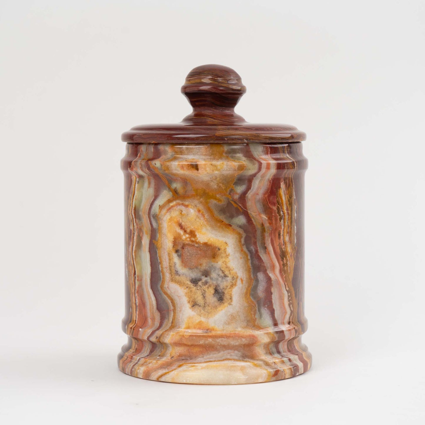 Vintage red onyx stone jar with lid showing rich oxblood and brown natural veining