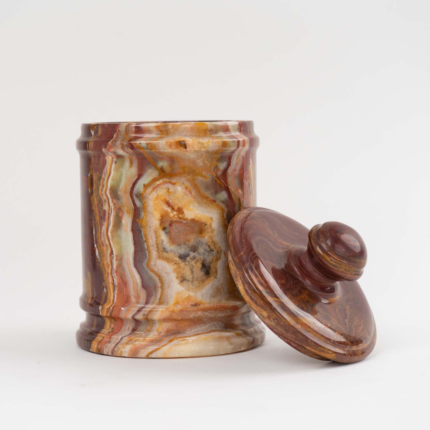 Vintage red onyx stone jar with lid showing rich oxblood and brown natural veining