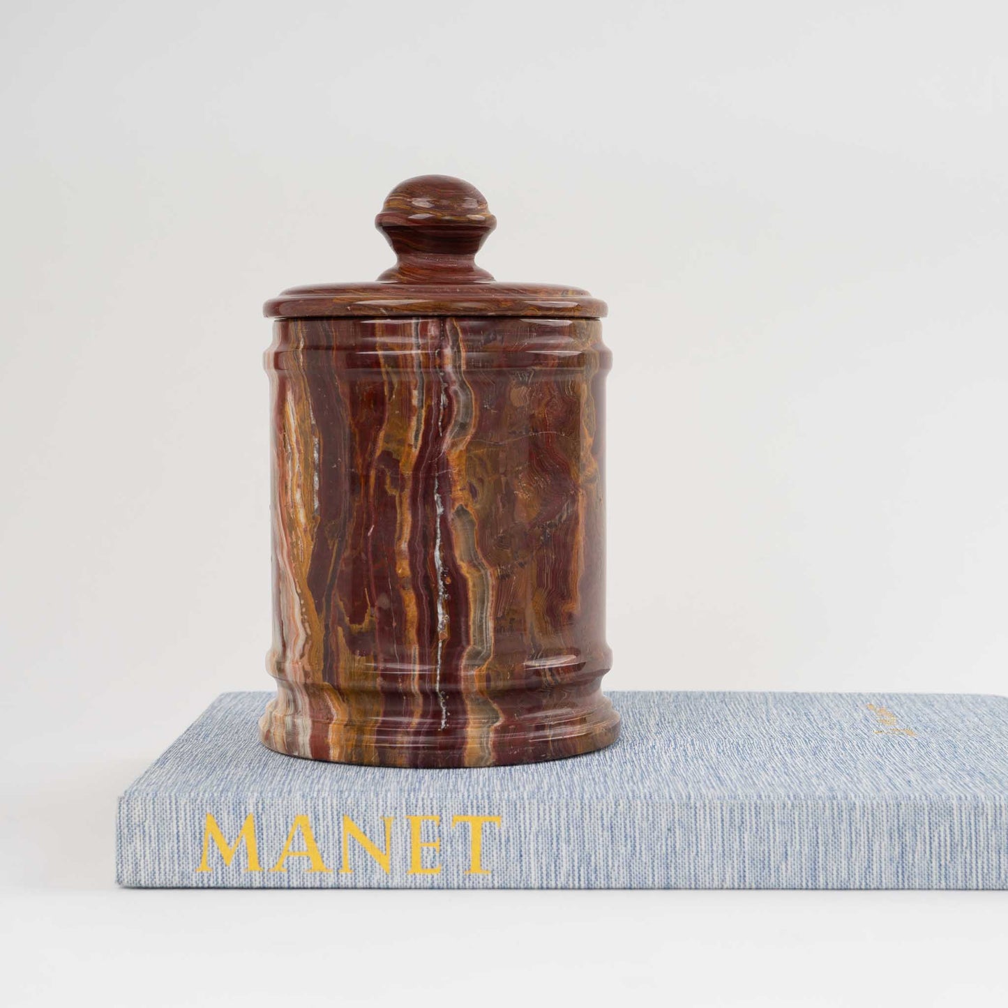 Vintage red onyx stone jar with lid showing rich oxblood and brown natural veining