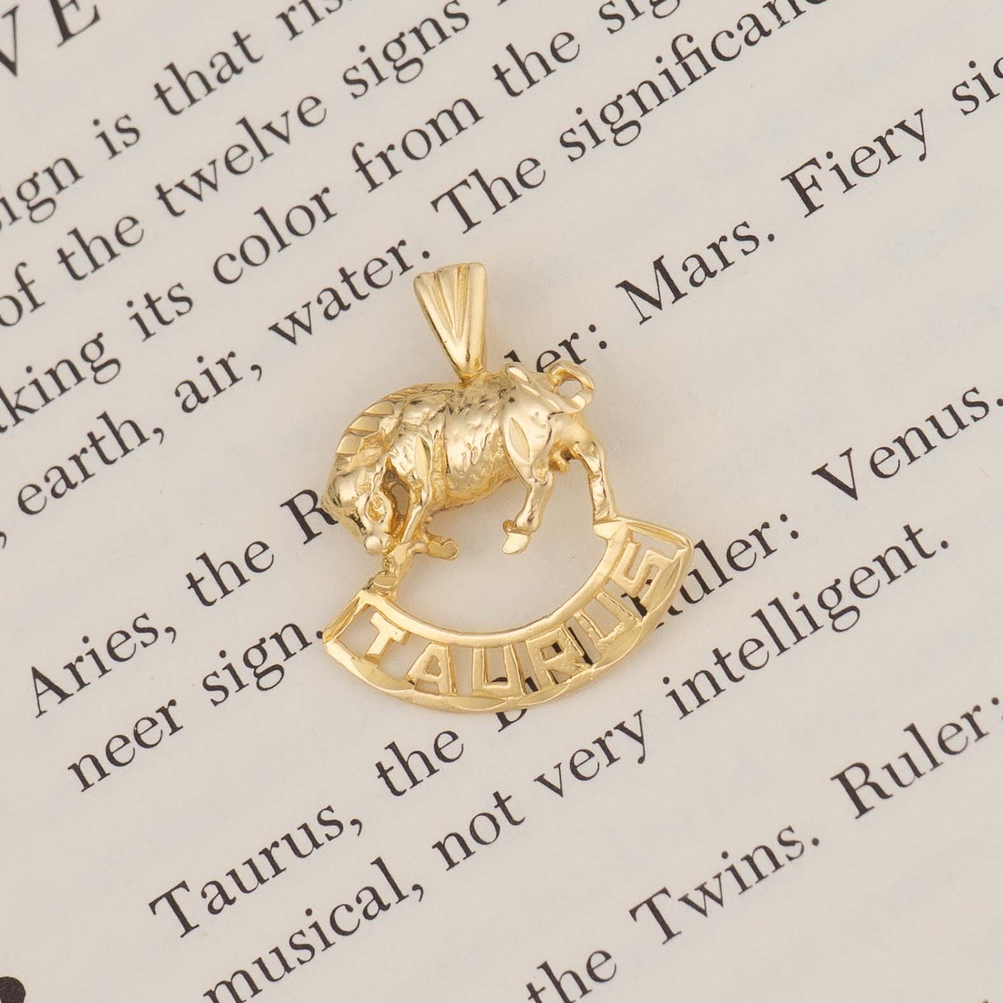 Vintage 14k yellow gold Taurus pendant with 3D bull design and Taurus text, showing front and back with 14K hallmark