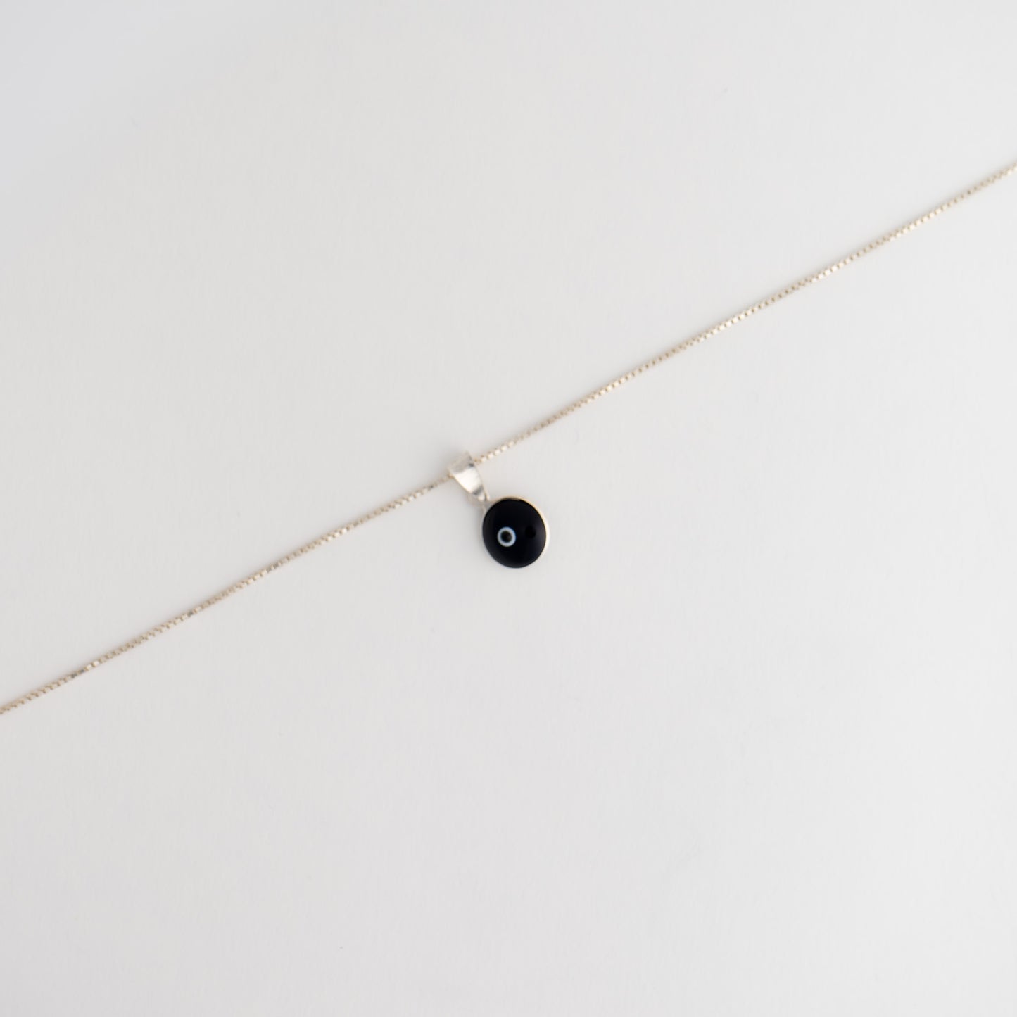 Handcrafted black and white glass evil eye pendant in sterling silver setting, made in Greece