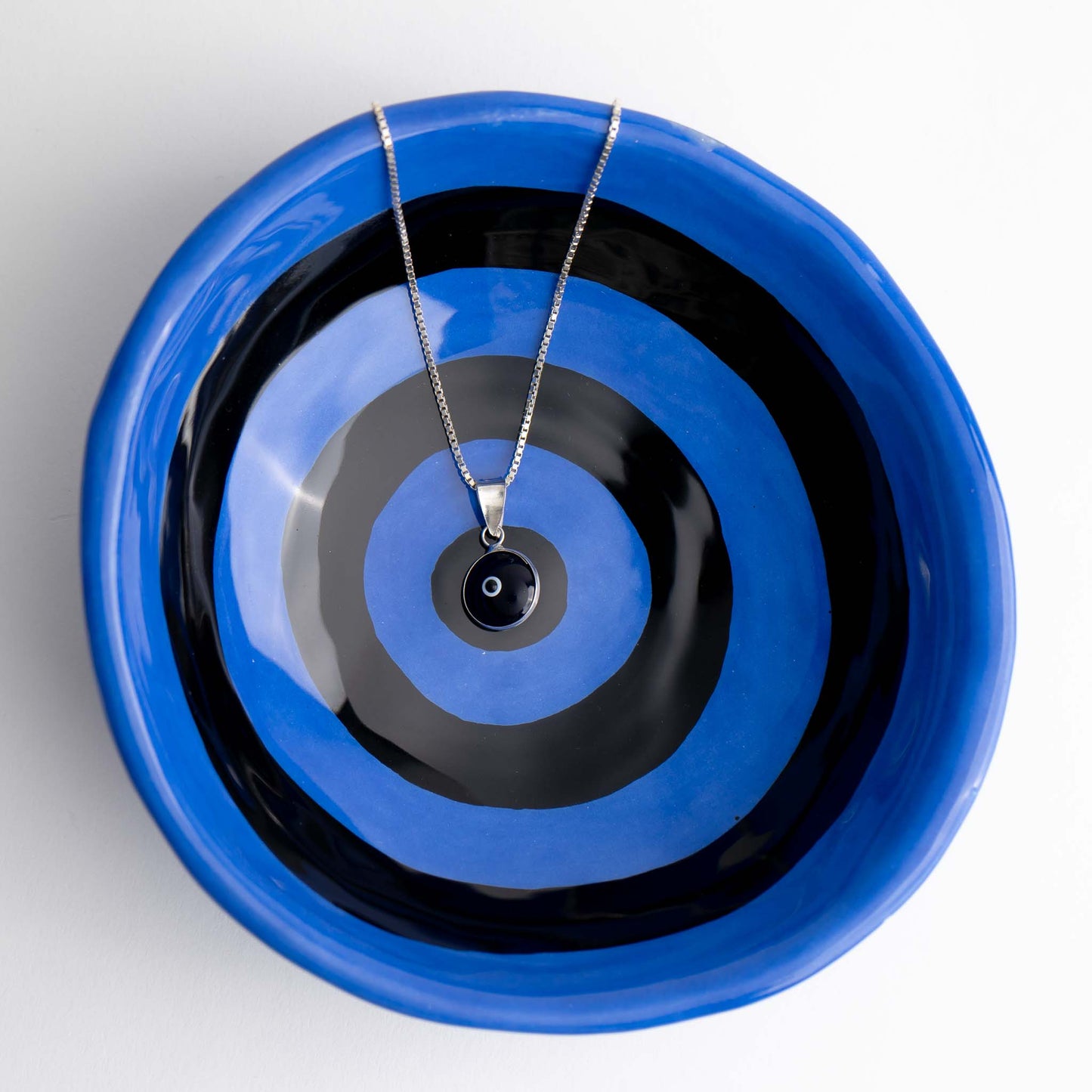 Handcrafted black and white glass evil eye pendant in sterling silver setting, made in Greece