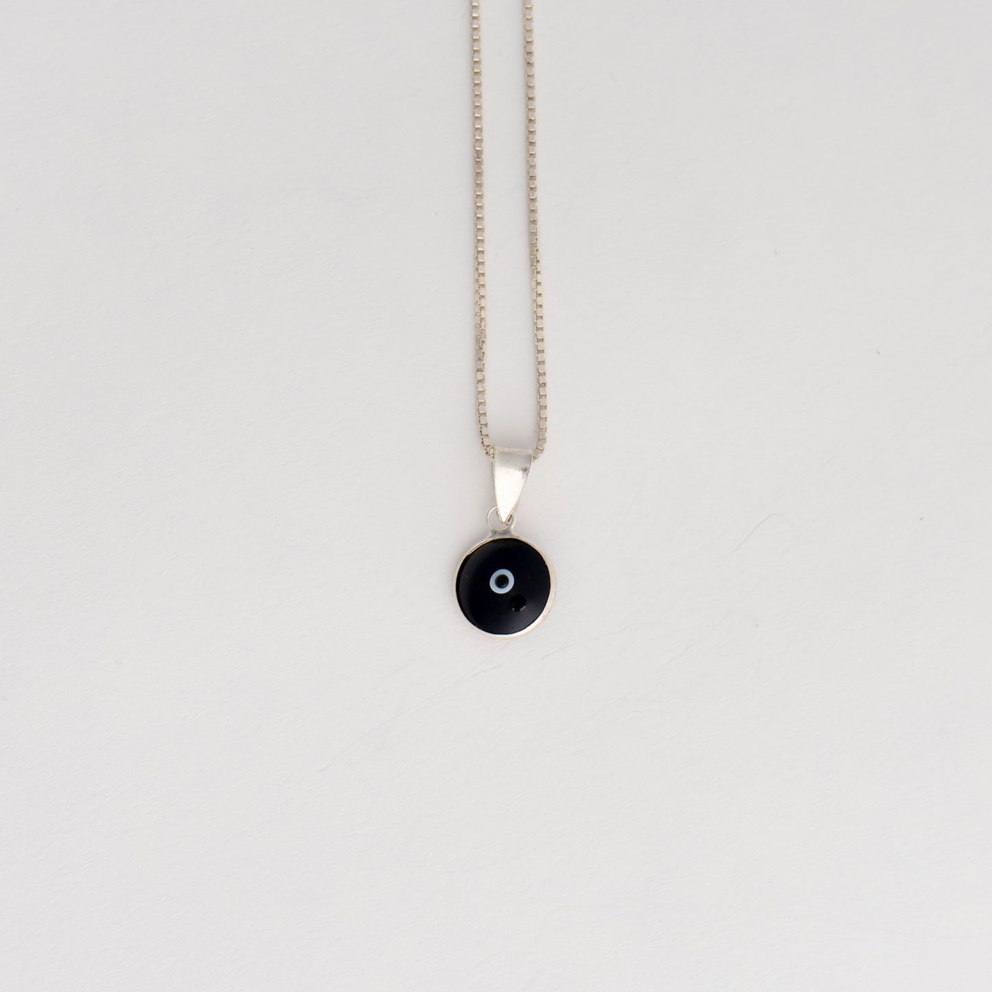 Handcrafted black and white glass evil eye pendant in sterling silver setting, made in Greece