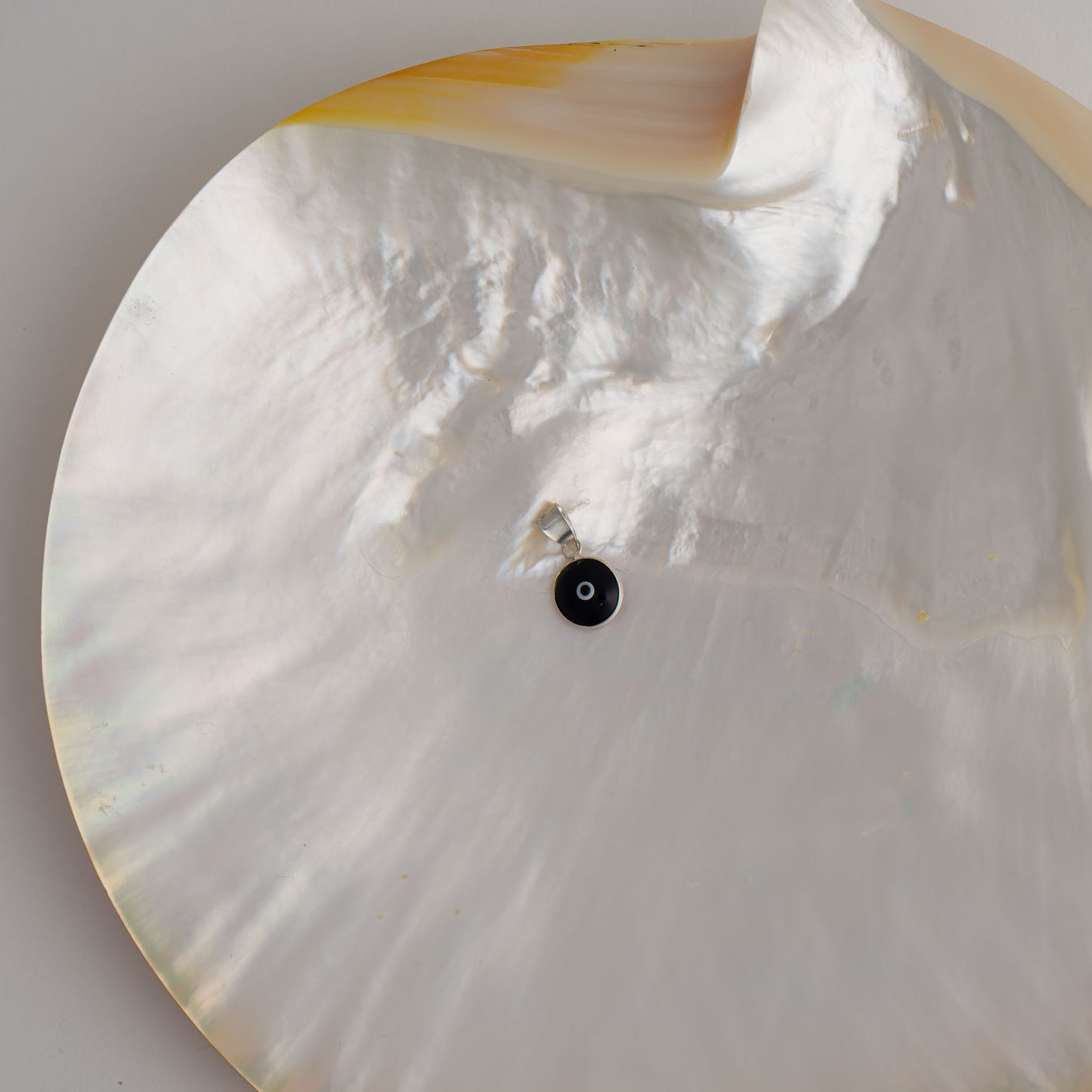 Handcrafted black and white glass evil eye pendant in sterling silver setting, made in Greece