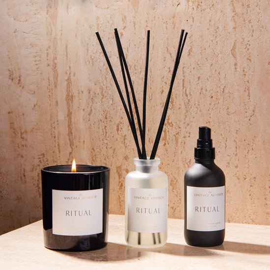 Ritual sacred space candle, reed diffuser and room spray on a luxurious travertine background