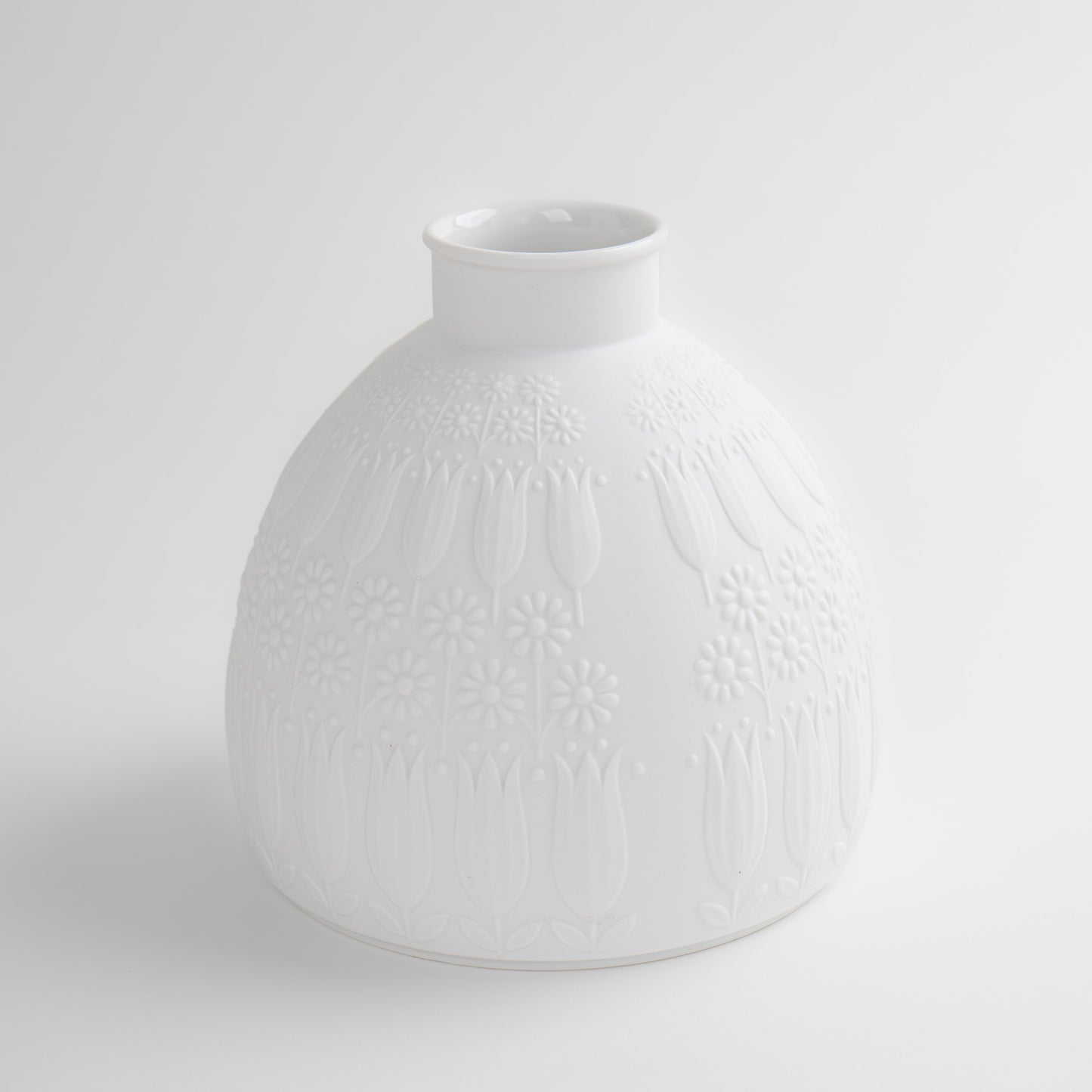 Vintage white porcelain vase with tulip and daisy relief design by Nanny Still for Heinrich & Co, Model #1904, made in Selb, Bavaria, Germany.