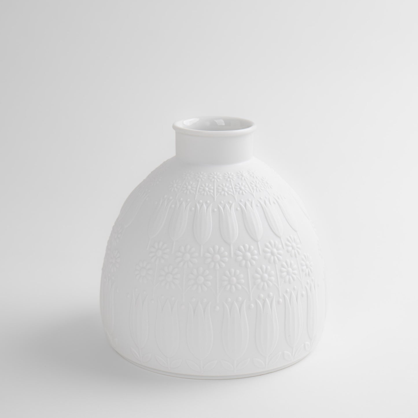 Vintage white porcelain vase with tulip and daisy relief design by Nanny Still for Heinrich & Co, Model #1904, made in Selb, Bavaria, Germany.