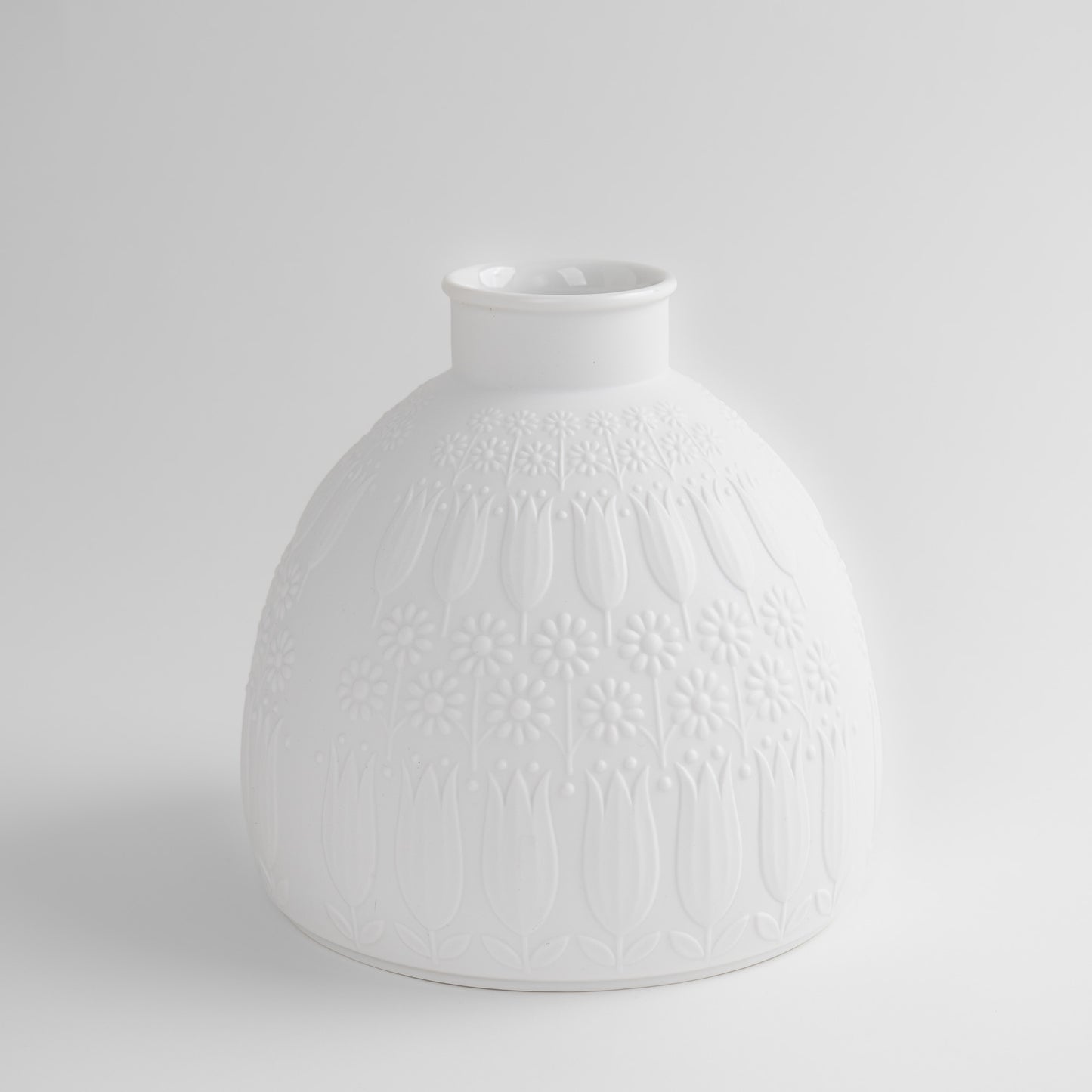 Vintage white porcelain vase with tulip and daisy relief design by Nanny Still for Heinrich & Co, Model #1904, made in Selb, Bavaria, Germany.