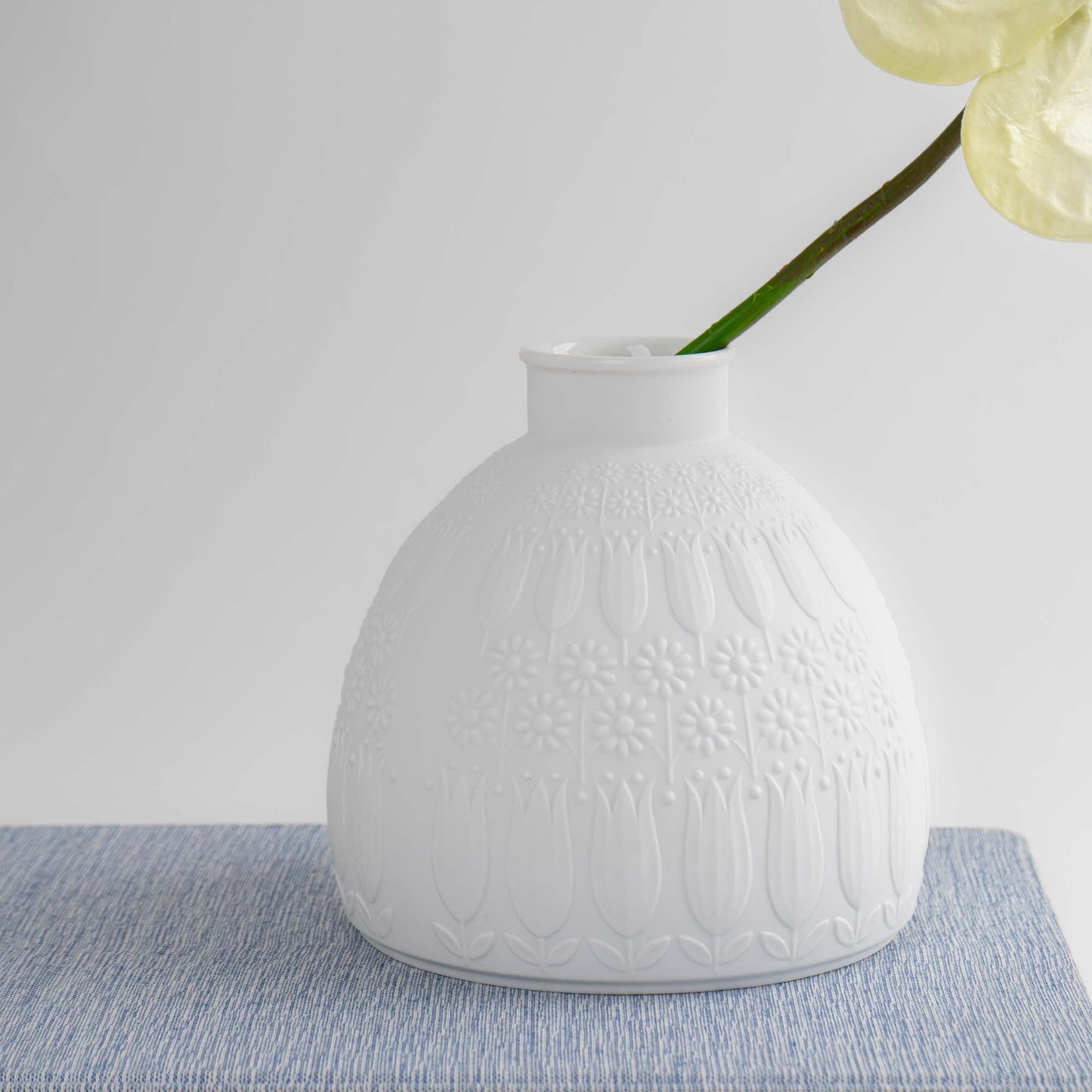 Vintage white porcelain vase with tulip and daisy relief design by Nanny Still for Heinrich & Co, Model #1904, made in Selb, Bavaria, Germany.