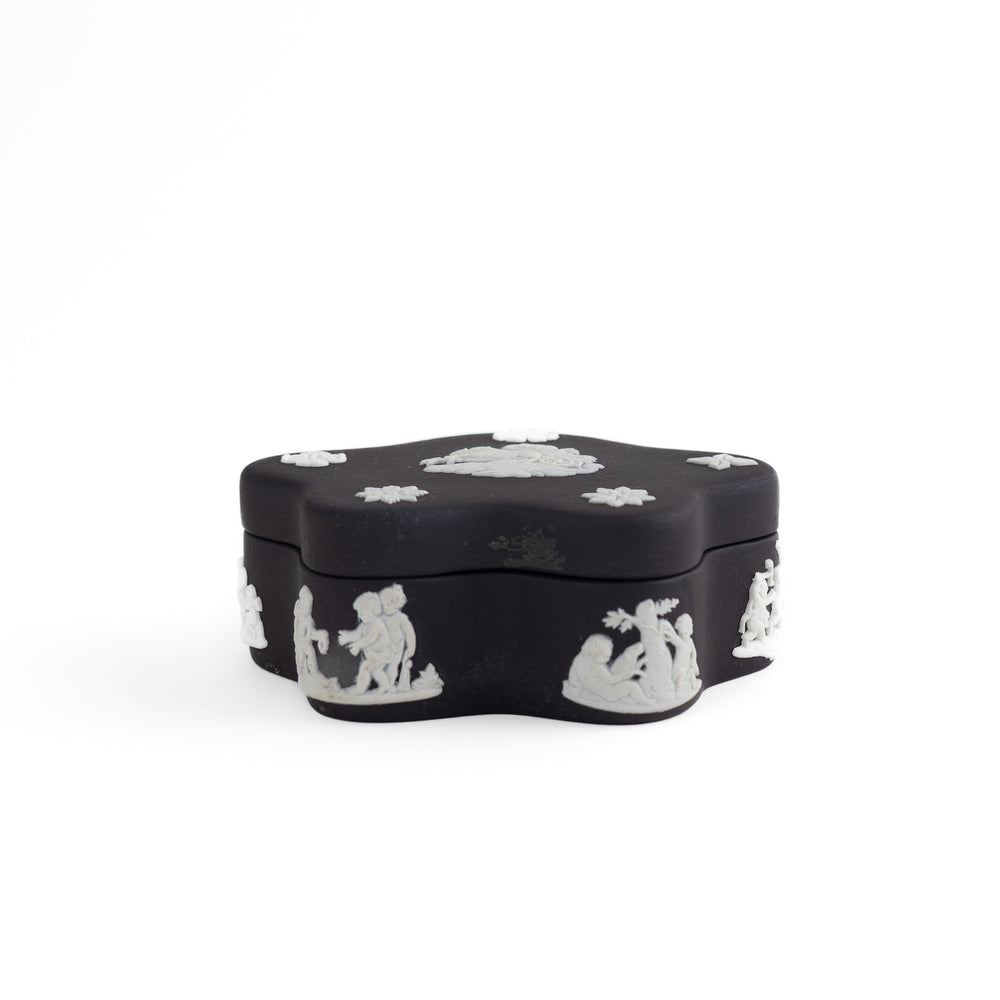 
                  
                    Vintage star-shaped Wedgwood black jasperware trinket box with white relief of Aurora Goddess of Dawn and cherub motifs, 1970s collectible.
                  
                