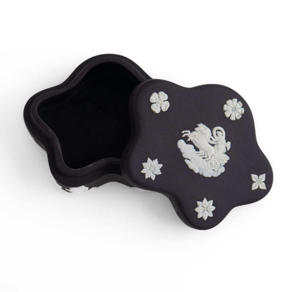 
                  
                    Vintage star-shaped Wedgwood black jasperware trinket box with white relief of Aurora Goddess of Dawn and cherub motifs, 1970s collectible.
                  
                