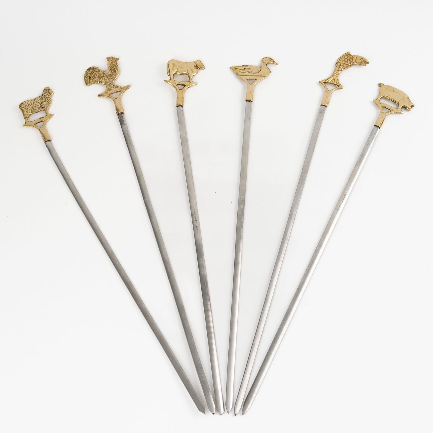 Set of six vintage brass animal barbecue skewers with stainless steel blades, featuring sheep, rooster, cow, duck, fish, and pig handles