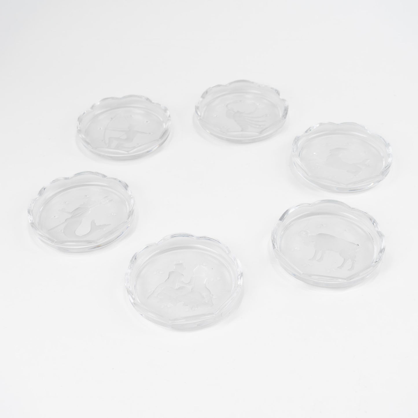 Set of six vintage crystal coasters with zodiac signs by Val Saint Lambert, featuring scalloped edges and frosted intaglio designs
