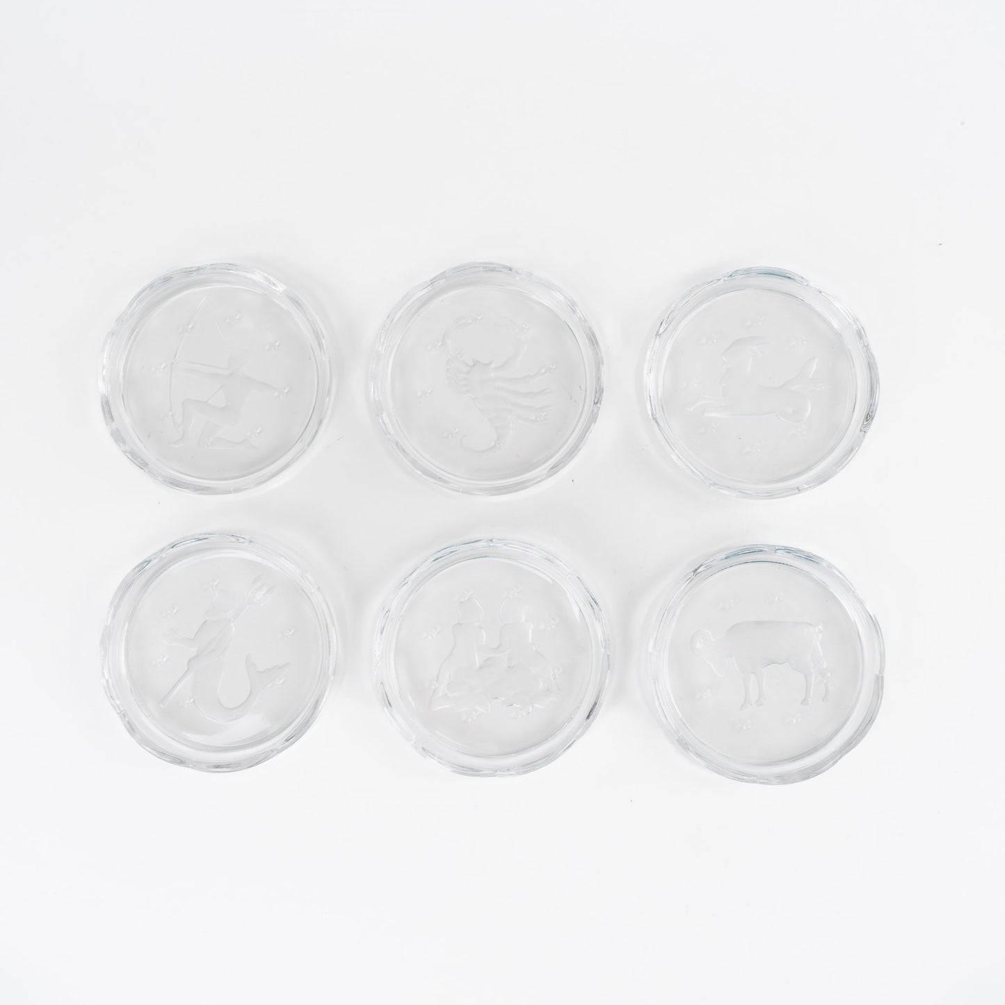 Set of six vintage crystal coasters with zodiac signs by Val Saint Lambert, featuring scalloped edges and frosted intaglio designs