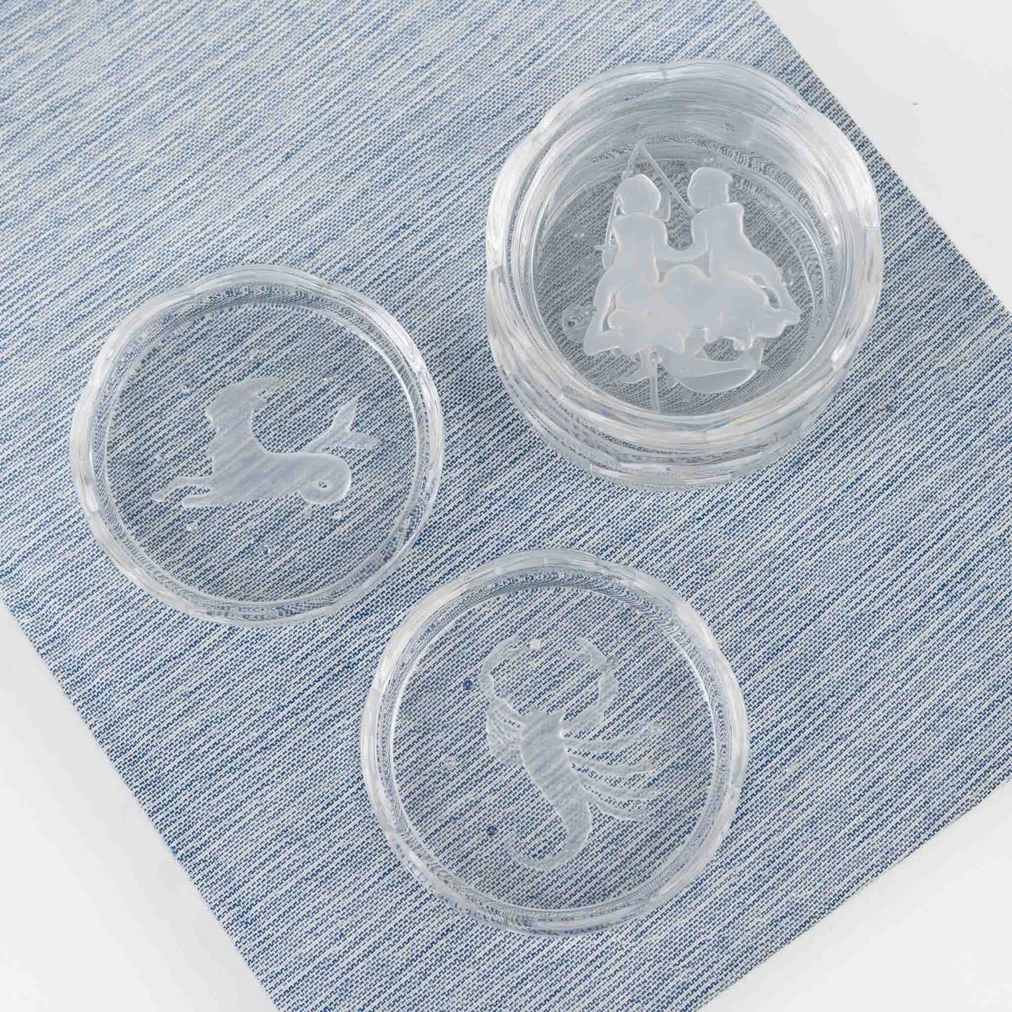 Set of six vintage crystal coasters with zodiac signs by Val Saint Lambert, featuring scalloped edges and frosted intaglio designs
