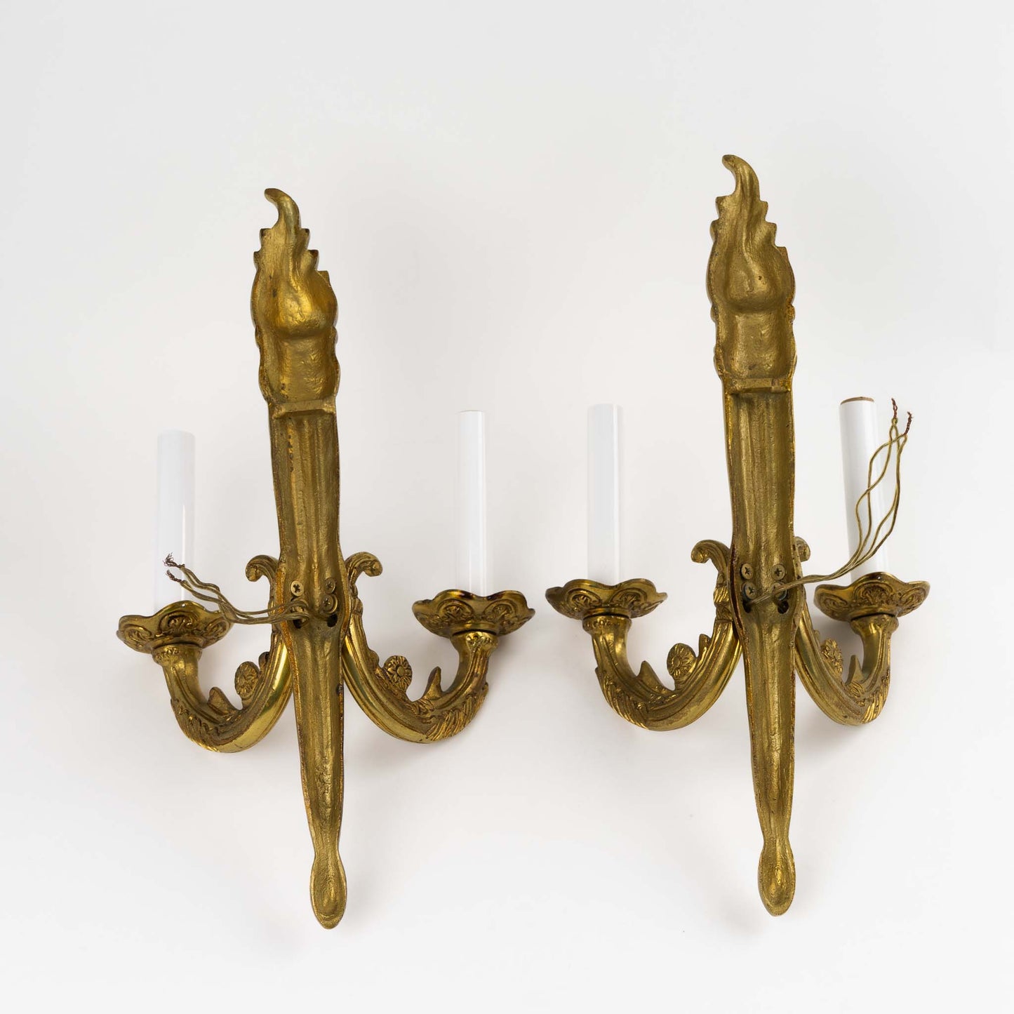 back view of vintage brass wall sconces in ornate Louis XV style with decorative scrollwork and dual bulb holders