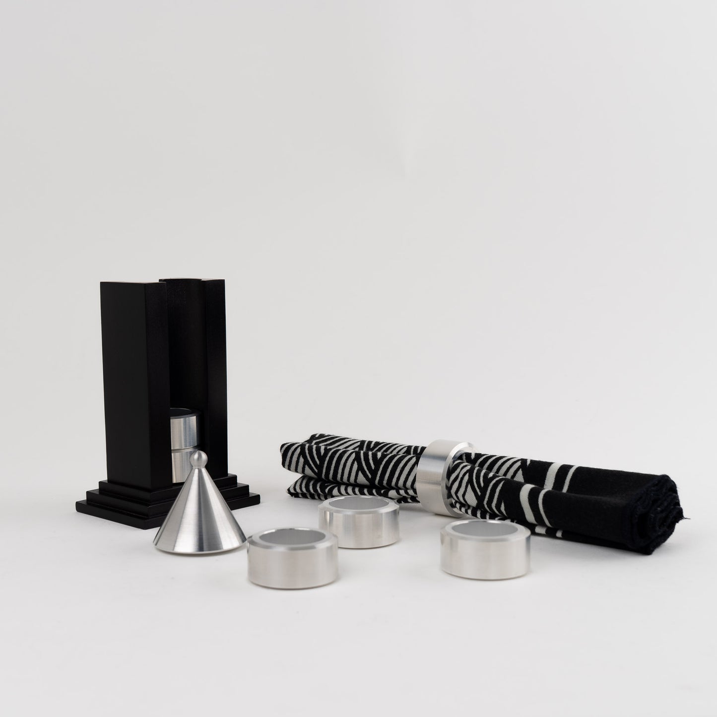 Vintage black building-shaped napkin ring holder displaying six silver metal napkin rings for elegant table setting storage