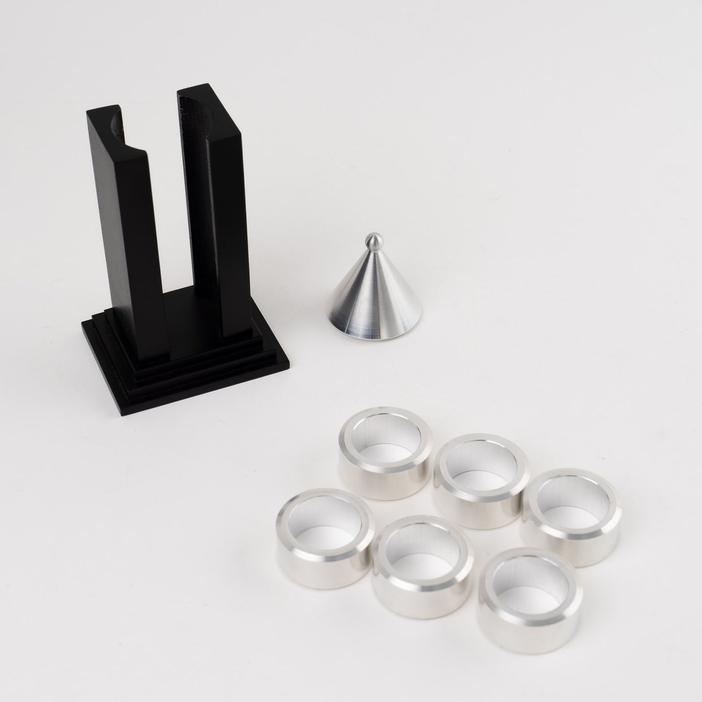Vintage black building-shaped napkin ring holder displaying six silver metal napkin rings for elegant table setting storage