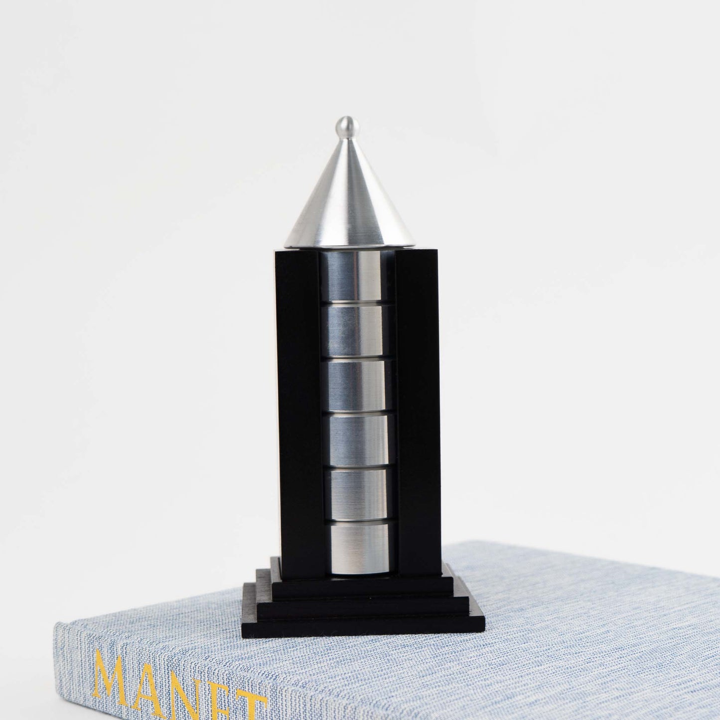 Vintage black building-shaped napkin ring holder displaying six silver metal napkin rings for elegant table setting storage