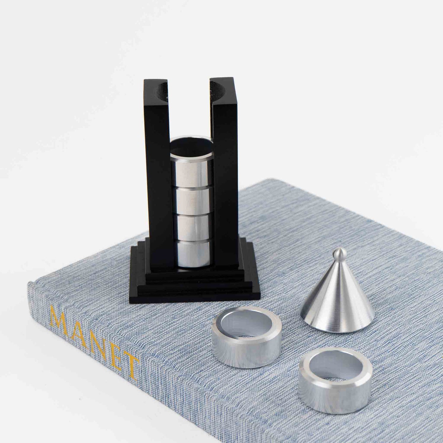 Vintage black building-shaped napkin ring holder displaying six silver metal napkin rings for elegant table setting storage