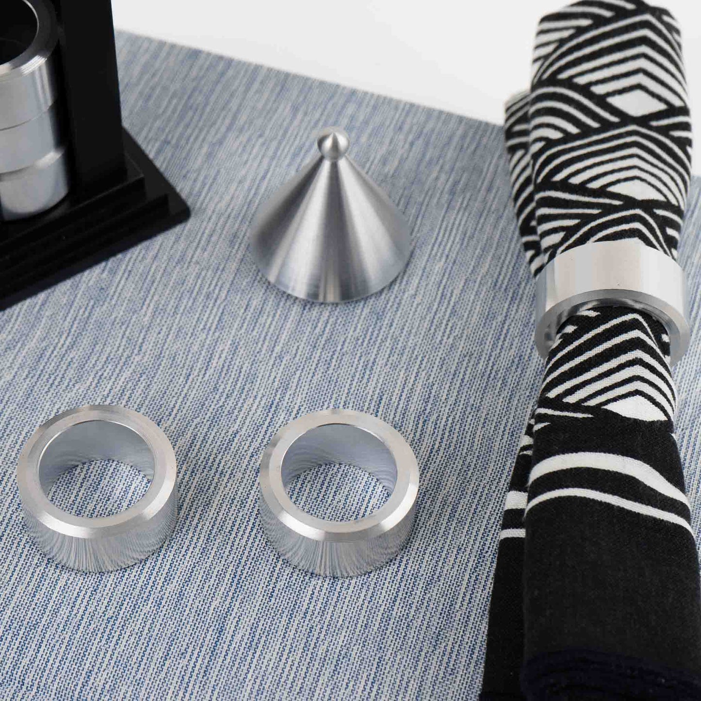 Vintage black building-shaped napkin ring holder displaying six silver metal napkin rings for elegant table setting storage