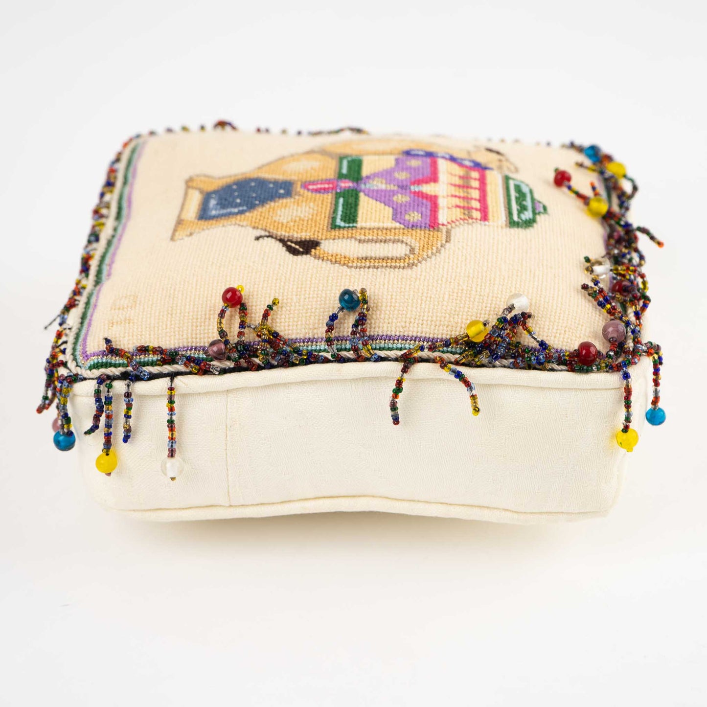 Vintage square needlepoint pillow with hand-stitched camel design and decorative beaded trim around edges
