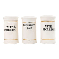 Set of three off-white ceramic apothecary jars with gold stripes and black vintage lettering with matching lids