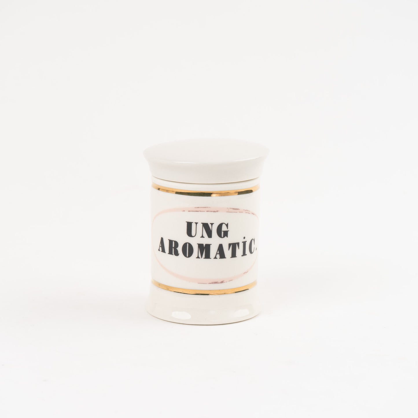 Ung aromatic off-white ceramic apothecary jar with gold accents and vintage pharmaceutical-style lettering, with matching lid