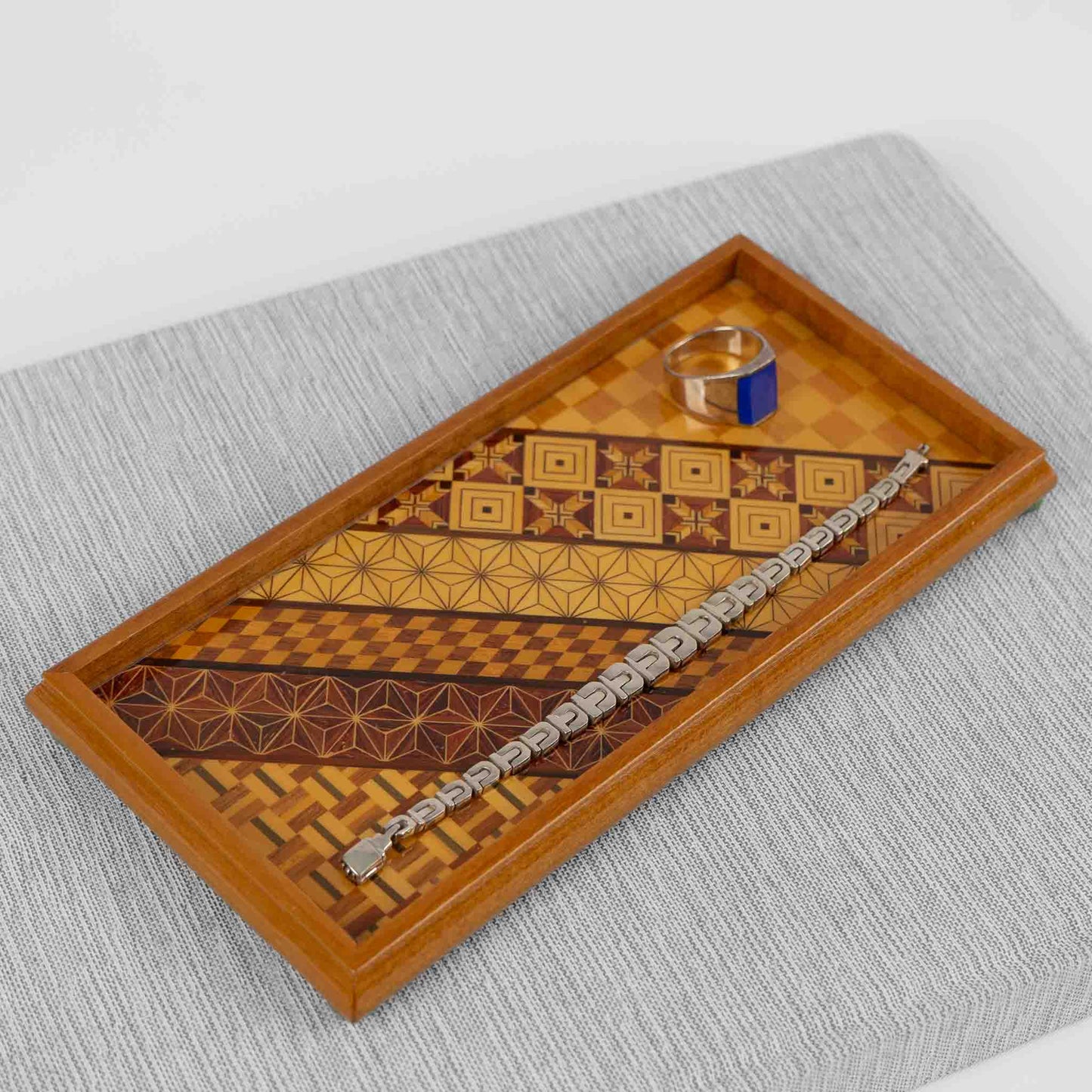 Vintage rectangular wood marquetry tray featuring six geometric patterns with contrasting wood tones and intricate inlay patterns