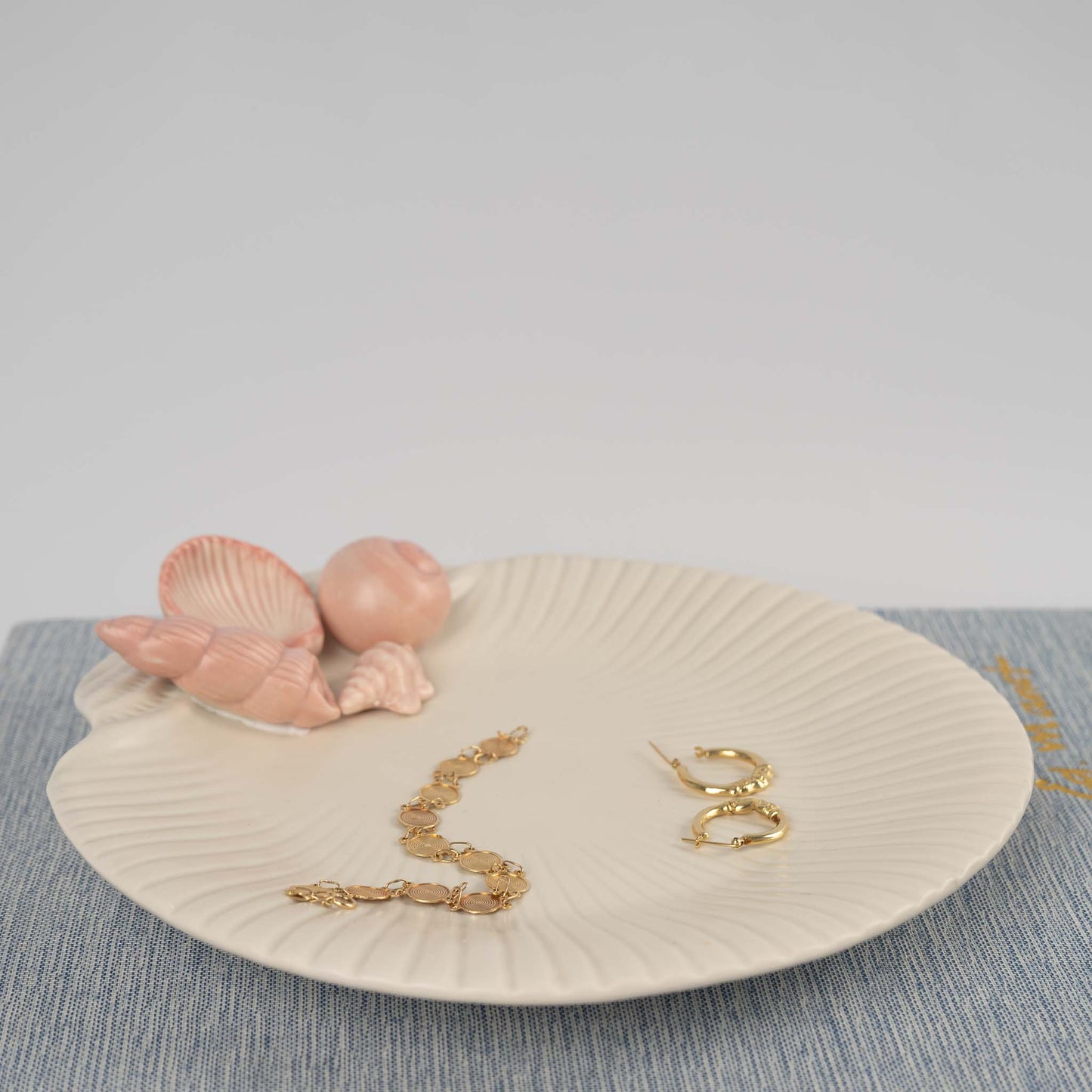 Vintage 1976 Fitz and Floyd ceramic seashell plate in off white with soft pink shell details used as a jewelry catchall 