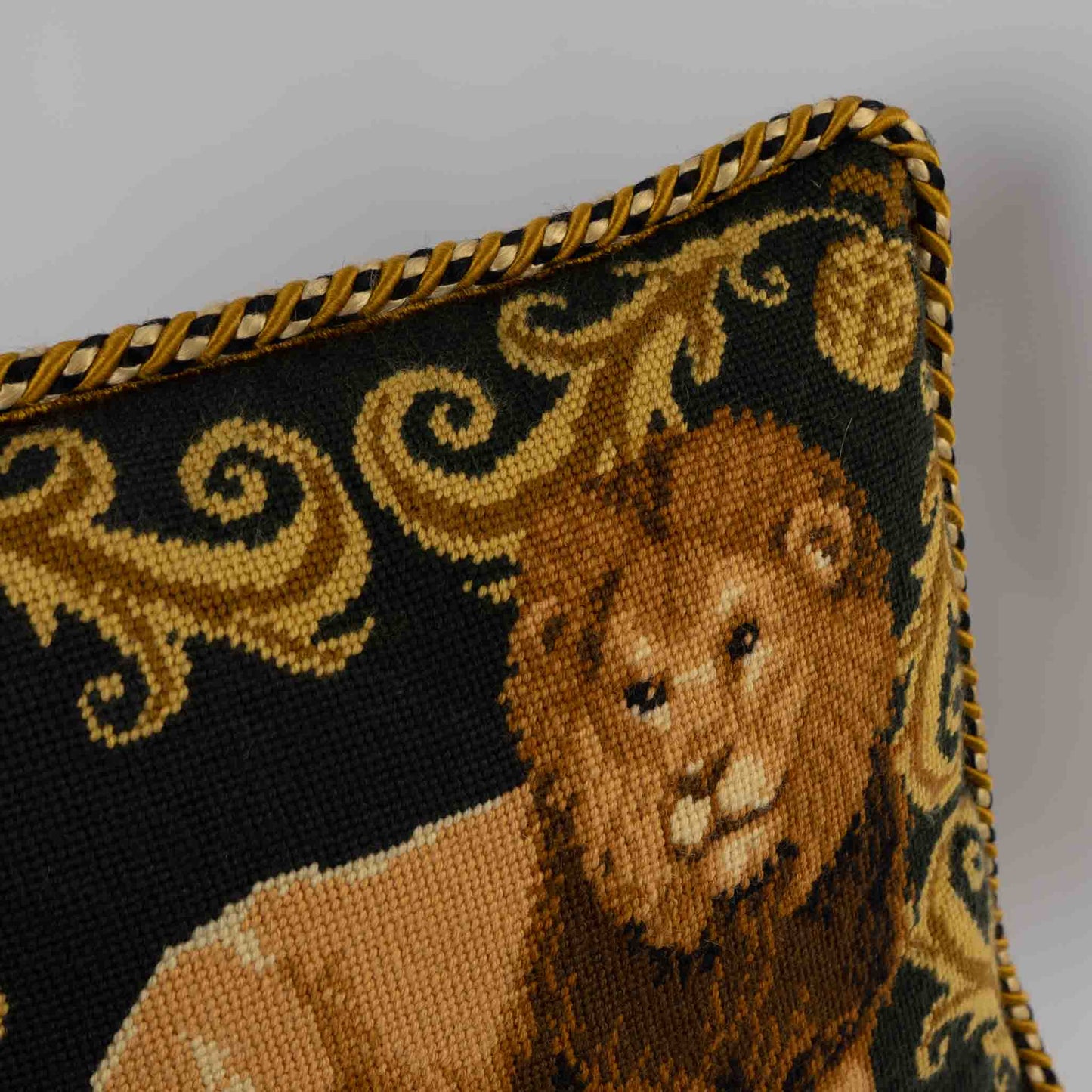 Vintage square needlepoint pillow featuring embroidered lion with decorative scroll border and braided rope piping