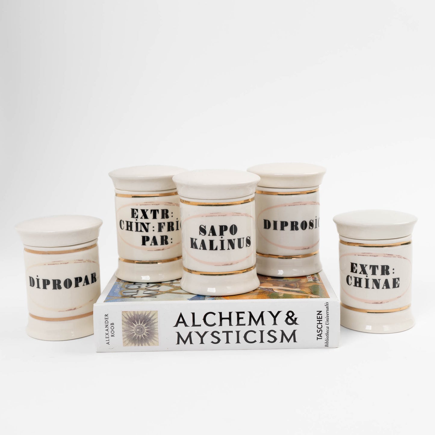 Set of 5 off-white ceramic apothecary jars with gold accents and vintage pharmaceutical-style lettering, each with matching lid