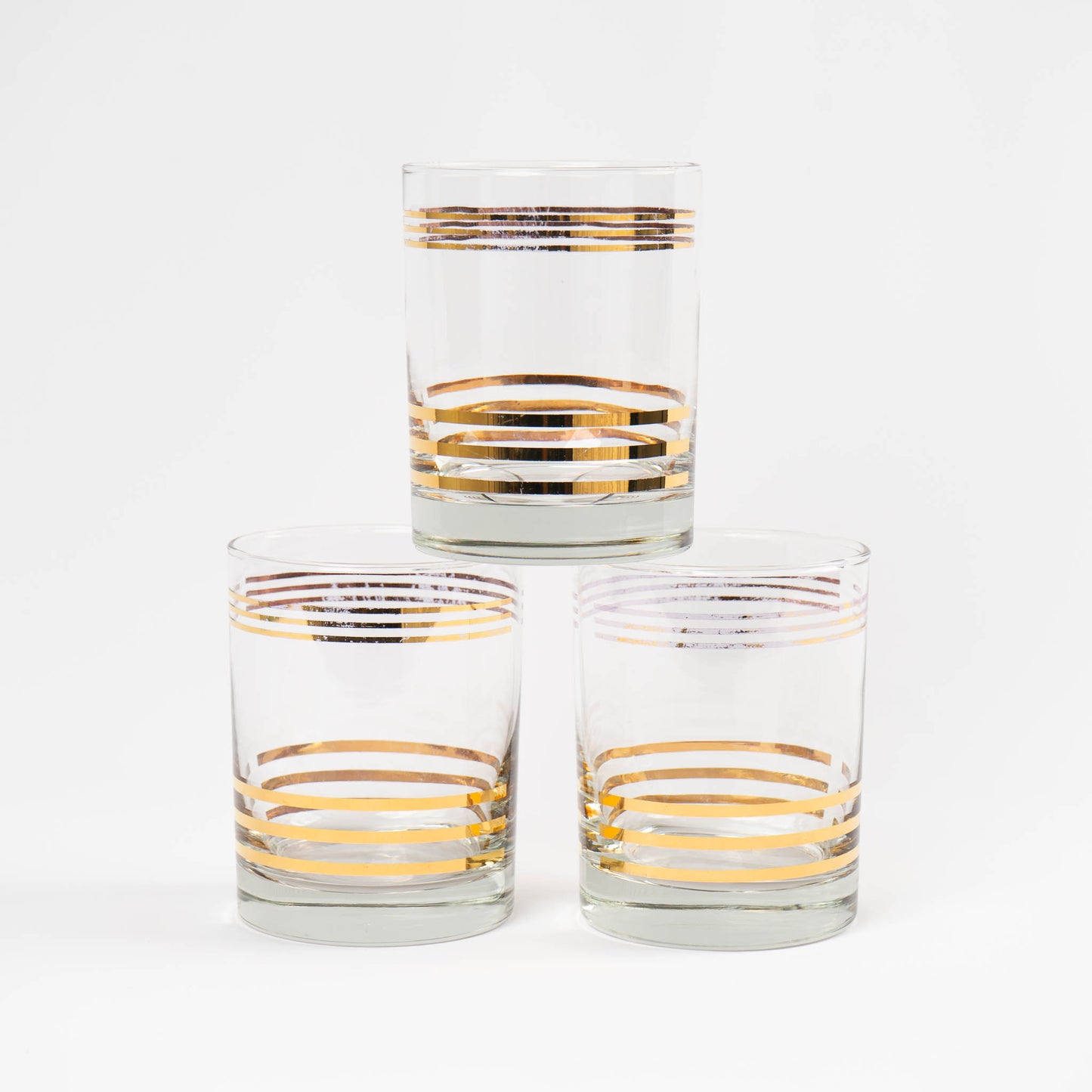 Set of three vintage lowball cocktail glasses with horizontal gold stripes 