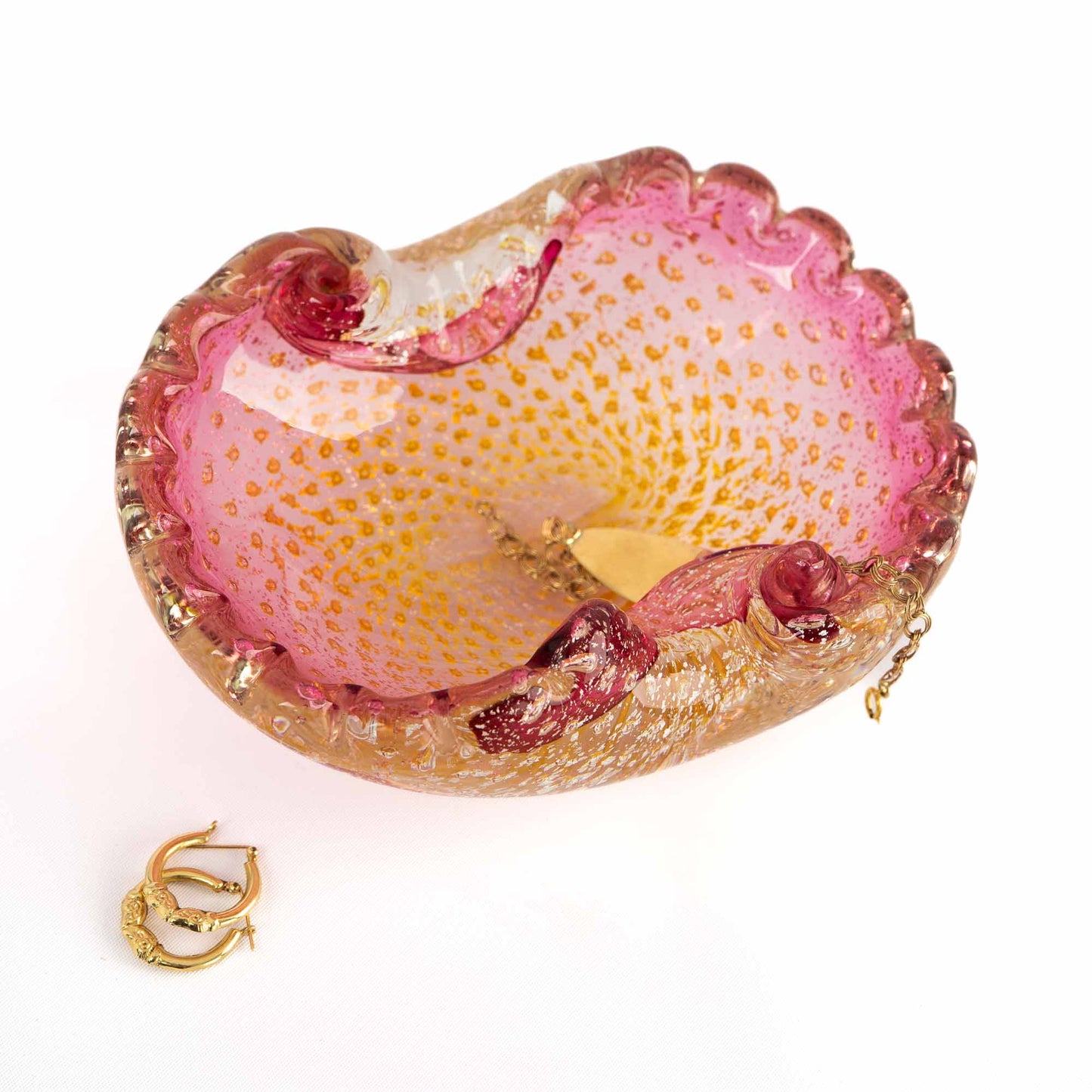 Vintage Murano Bullicante art glass catchall dish in pink and yellow with gold aventurine flecks and scalloped edge, shown holding vintage gold jewelry