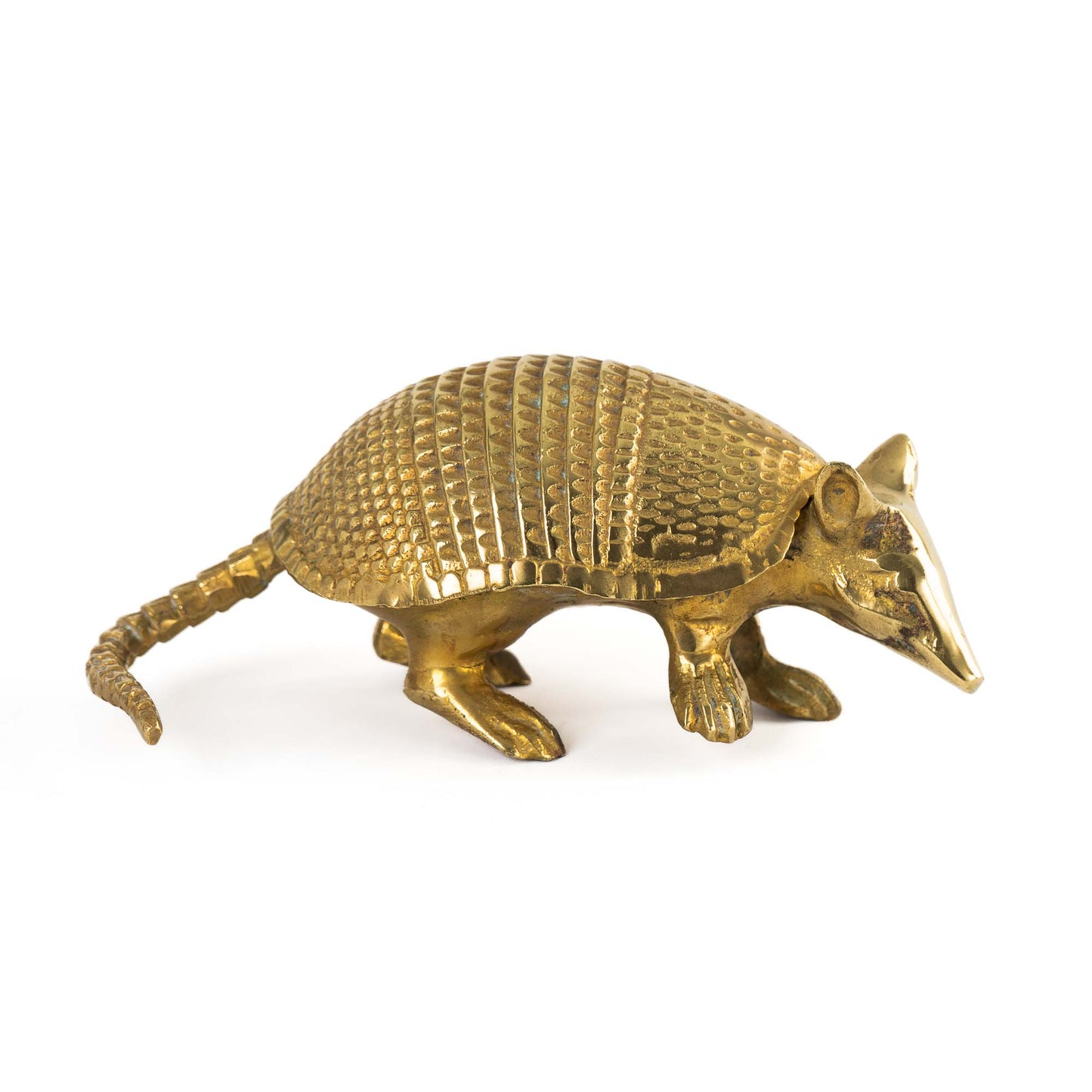 Vintage solid cast brass armadillo figurine with detailed segmented shell, circa 1970s–1980s, shown on a flat surface.