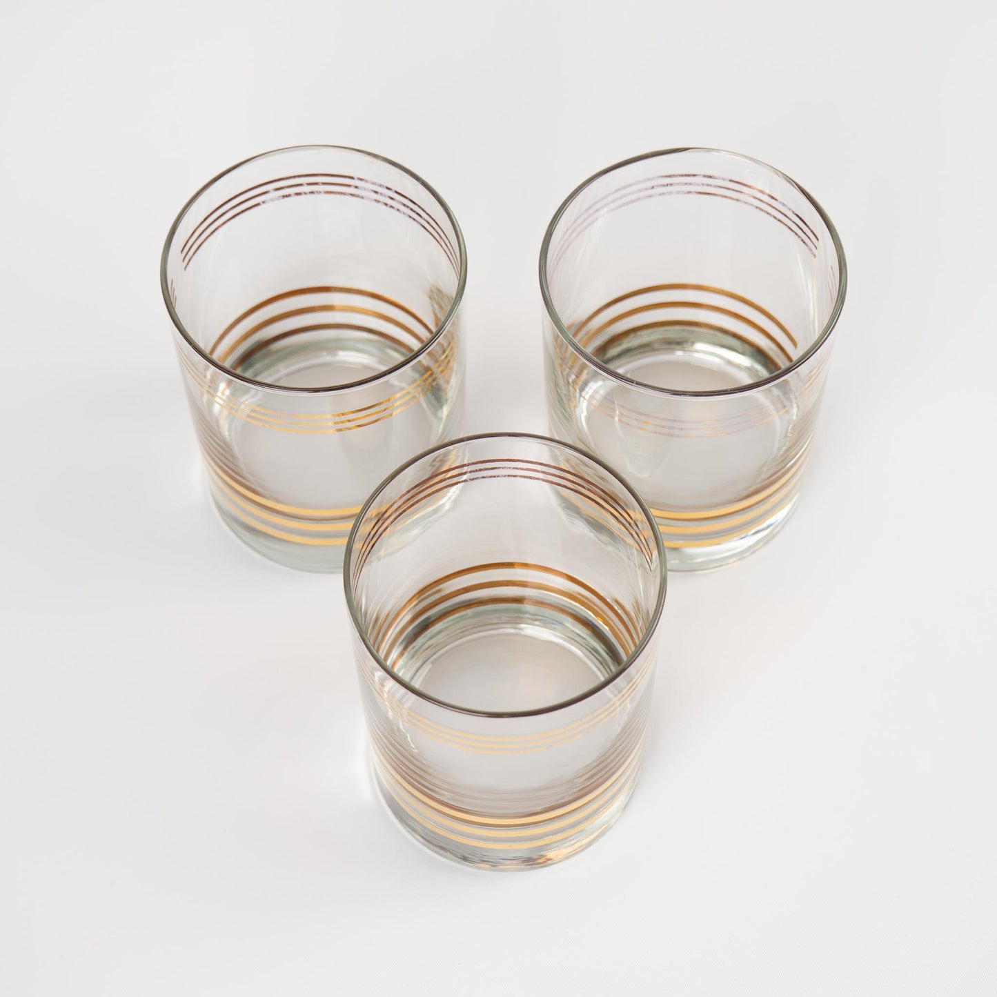 Set of three vintage lowball cocktail glasses with horizontal gold stripes 
