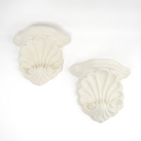 Pair of vintage white plaster shell scroll corbel wall shelves displayed side by side.