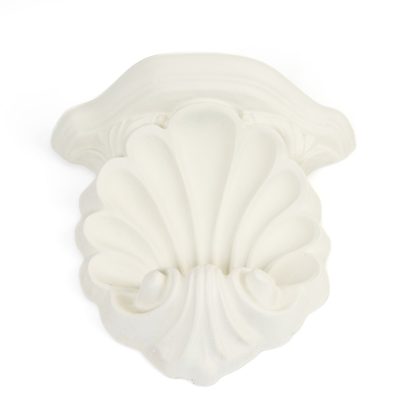 Close-up of a vintage white plaster wall shelf with ornate shell and scroll corbel detailing