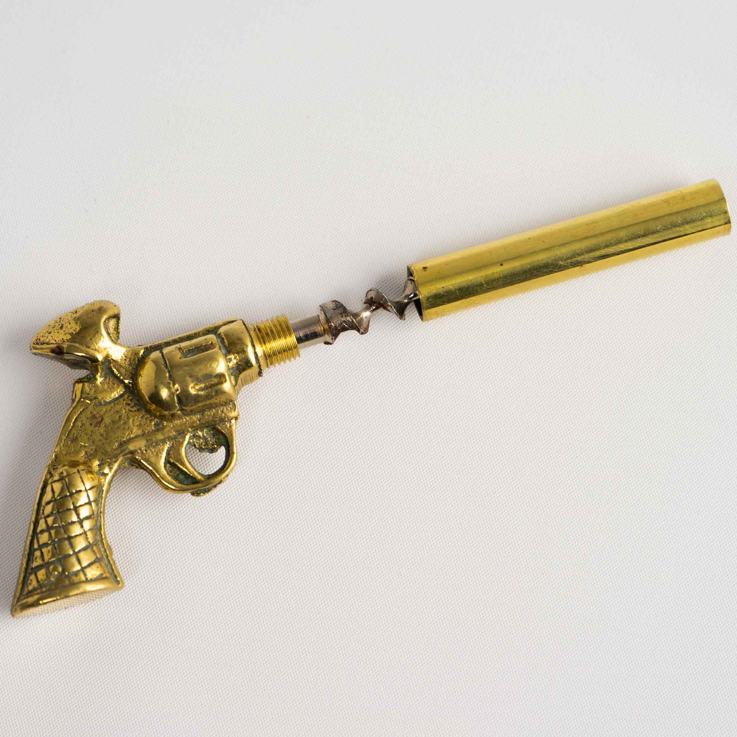 Vintage brass revolver corkscrew unscrewed apart to reveal the spiral corkscrew mechanism concealed within the barrel