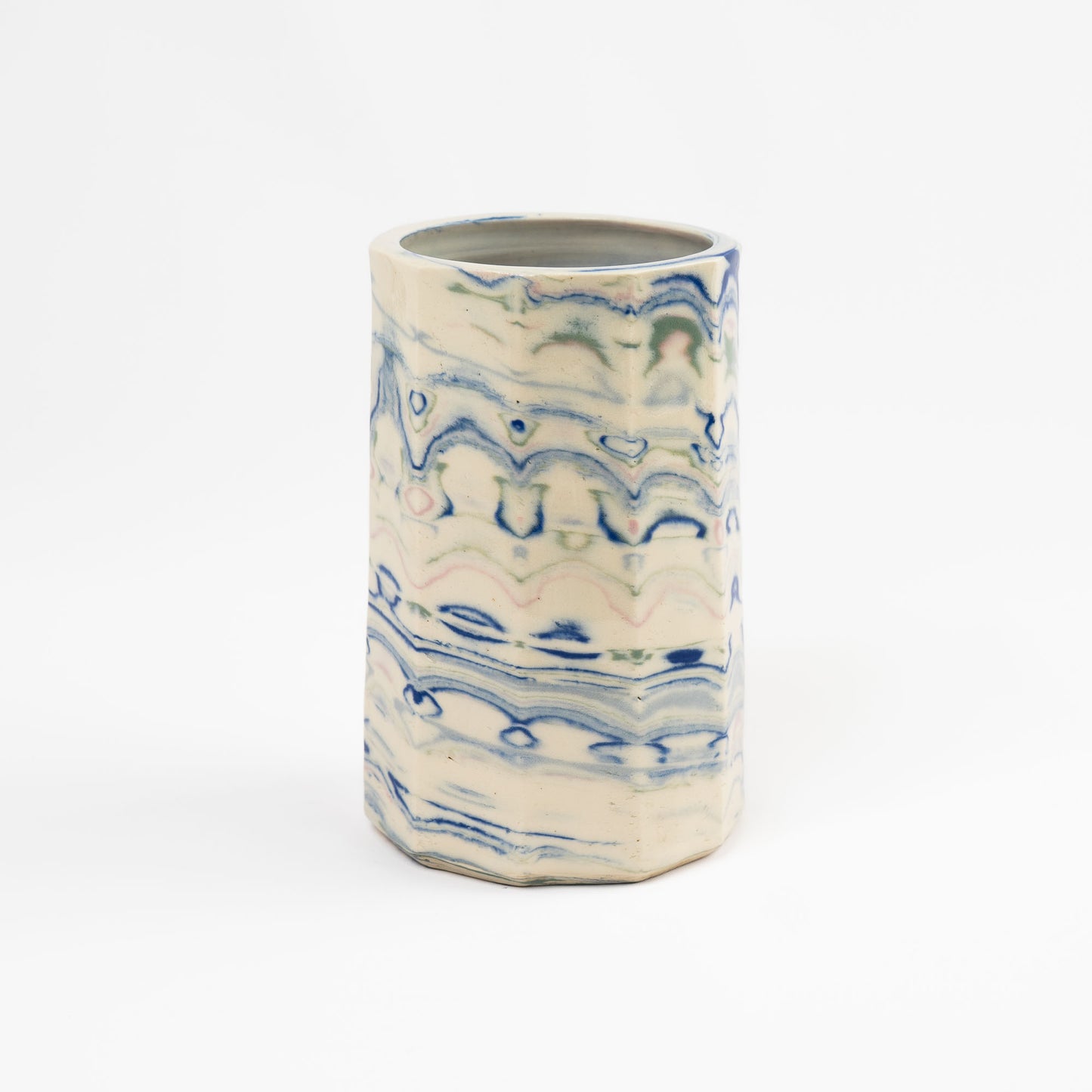 Vintage cylindrical Nerikomi marbled ceramic vase with swirling blue, green, and pink tones on an off-white ground, signed and dated 1982.