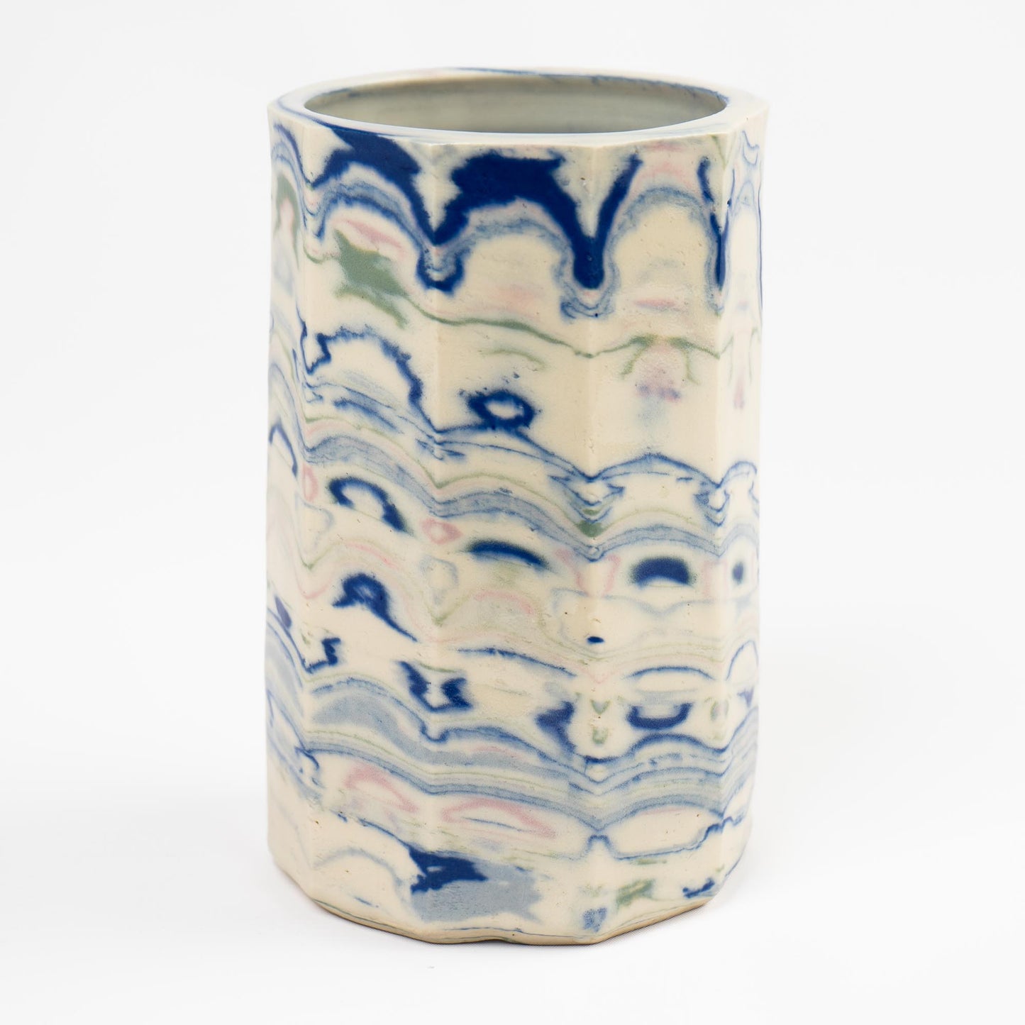 Vintage cylindrical Nerikomi marbled ceramic vase with swirling blue, green, and pink tones on an off-white ground, signed and dated 1982.