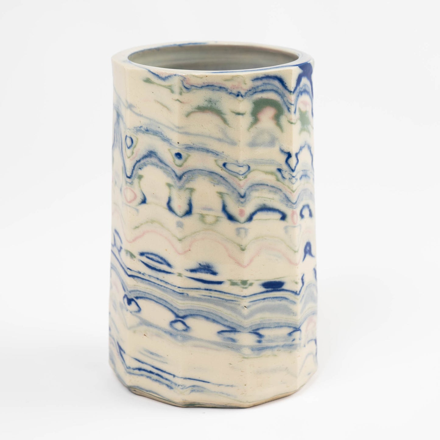 Vintage cylindrical Nerikomi marbled ceramic utensil holder with swirling blue, green, and pink tones on an off-white ground, signed and dated 1982.