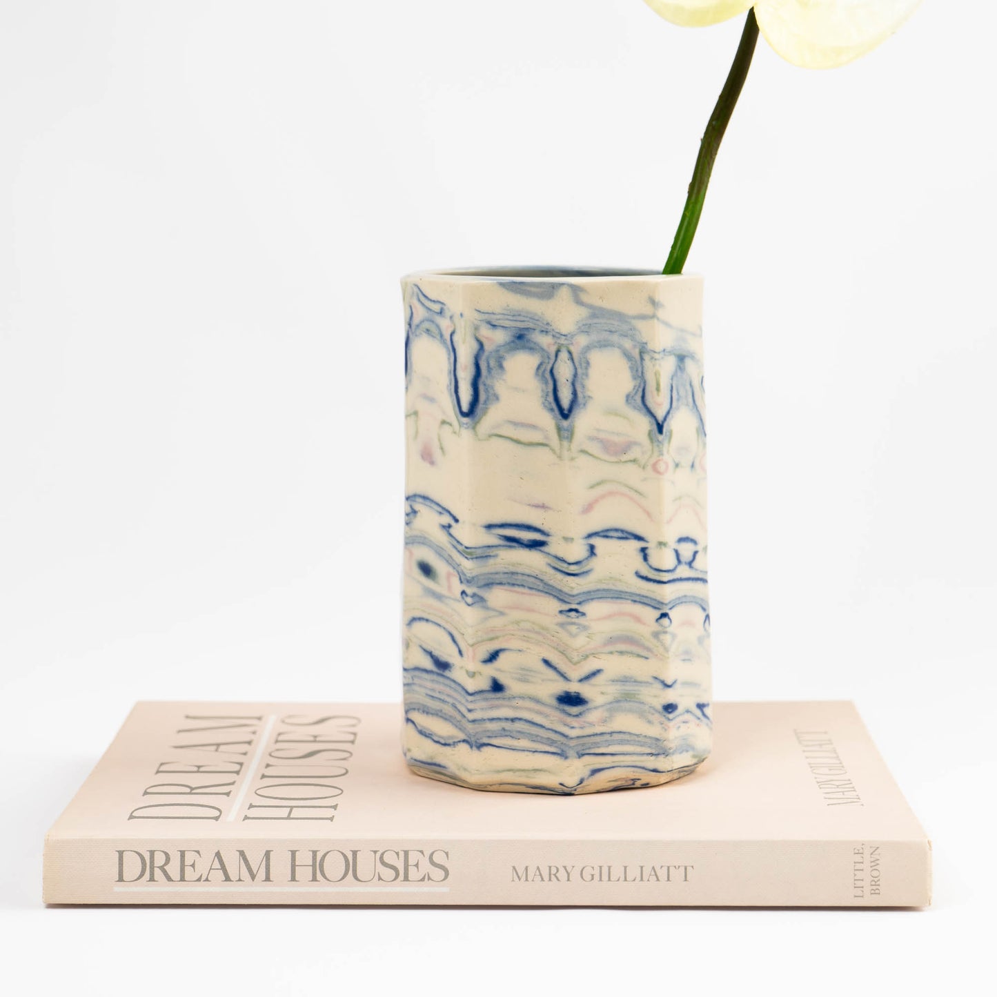 Vintage cylindrical Nerikomi marbled ceramic vessel with swirling blue, green, and pink tones on an off-white ground, signed and dated 1982. 