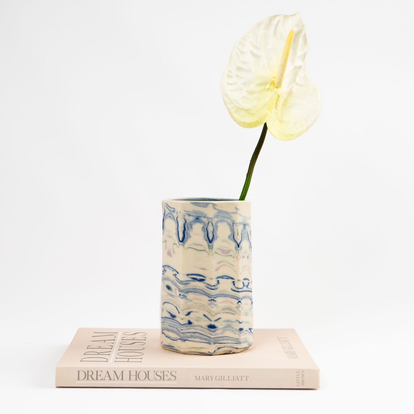 Vintage cylindrical Nerikomi marbled ceramic vase with swirling blue, green, and pink tones on an off-white ground, signed and dated 1982. 