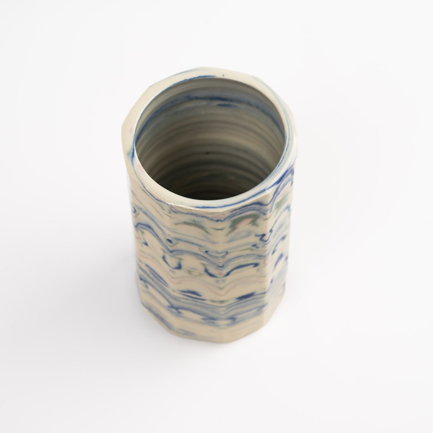 Vintage cylindrical Nerikomi marbled ceramic vase with swirling blue, green, and pink tones on an off-white ground, signed and dated 1982.