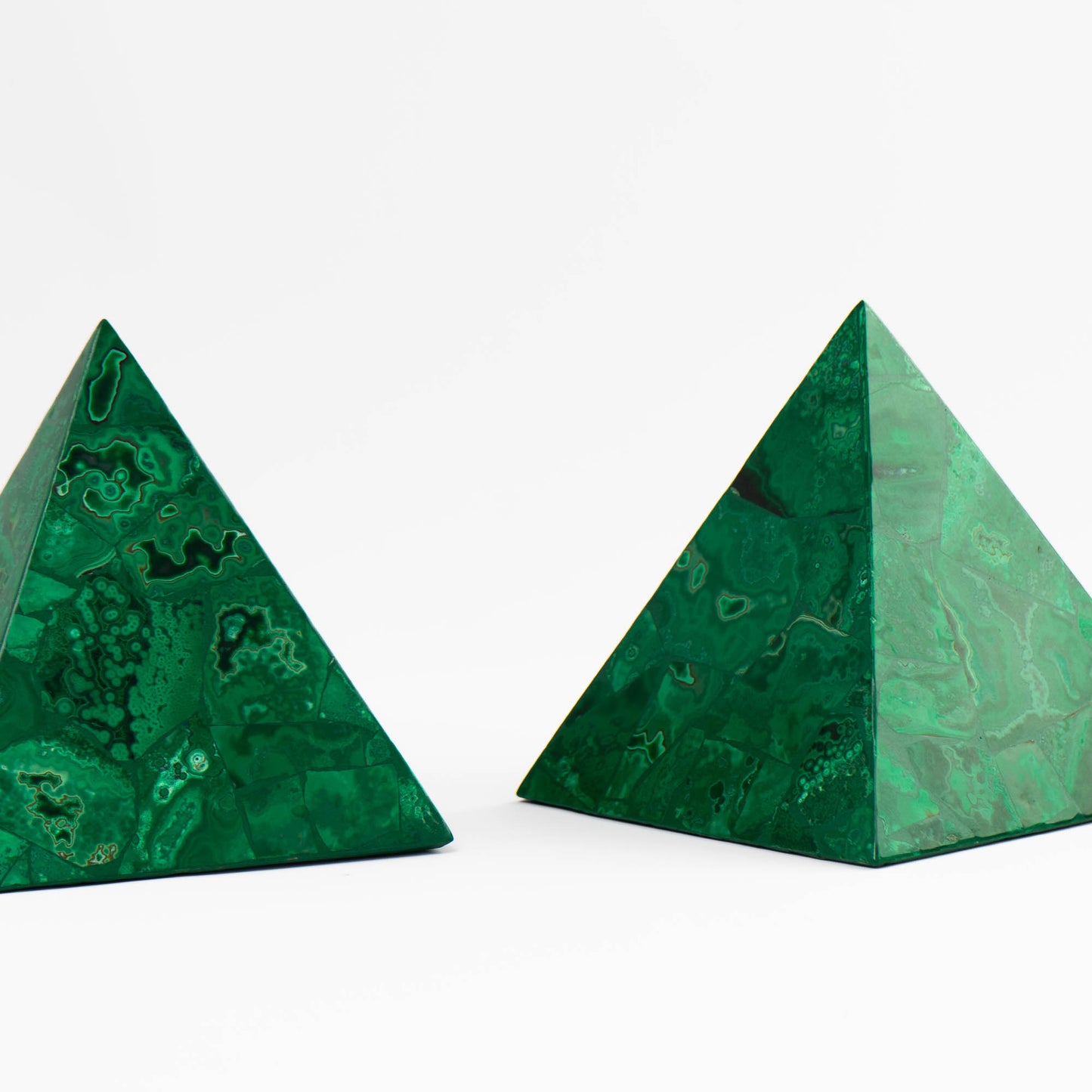 Pair of polished green malachite pyramid sculptures with natural banded stone pattern.